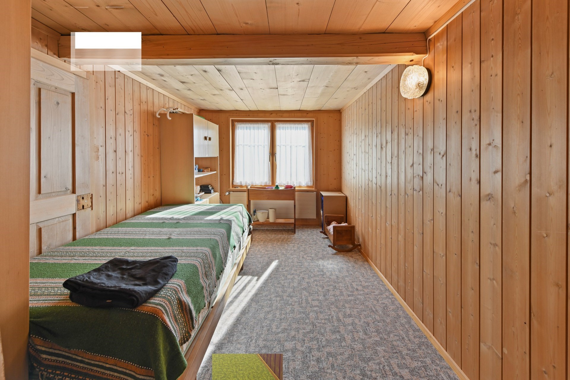 Holzverkleidetes Schlafzimmer mit Einzelbett