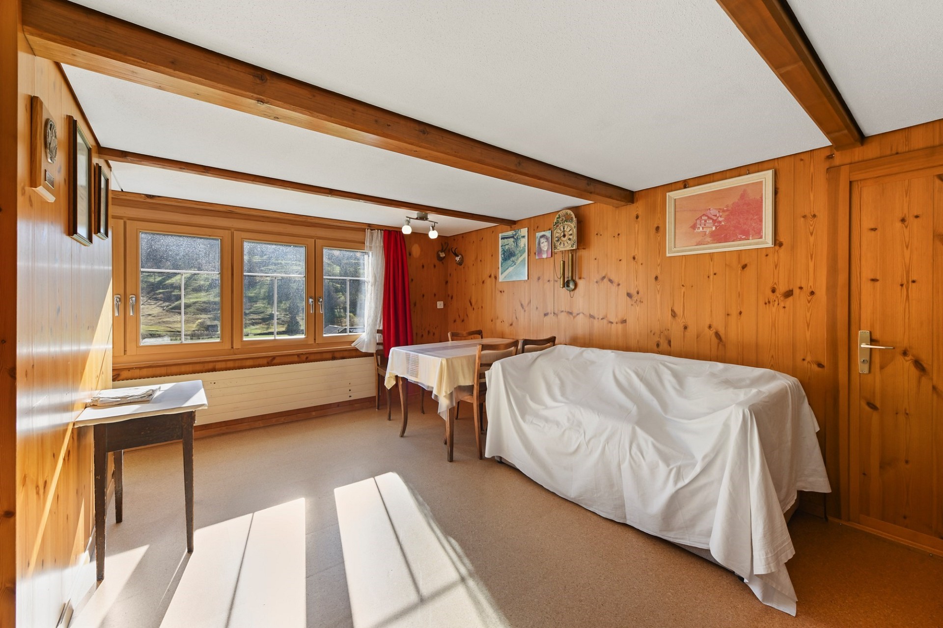 Holzvertäfeltes Zimmer mit einfacher Möblierung