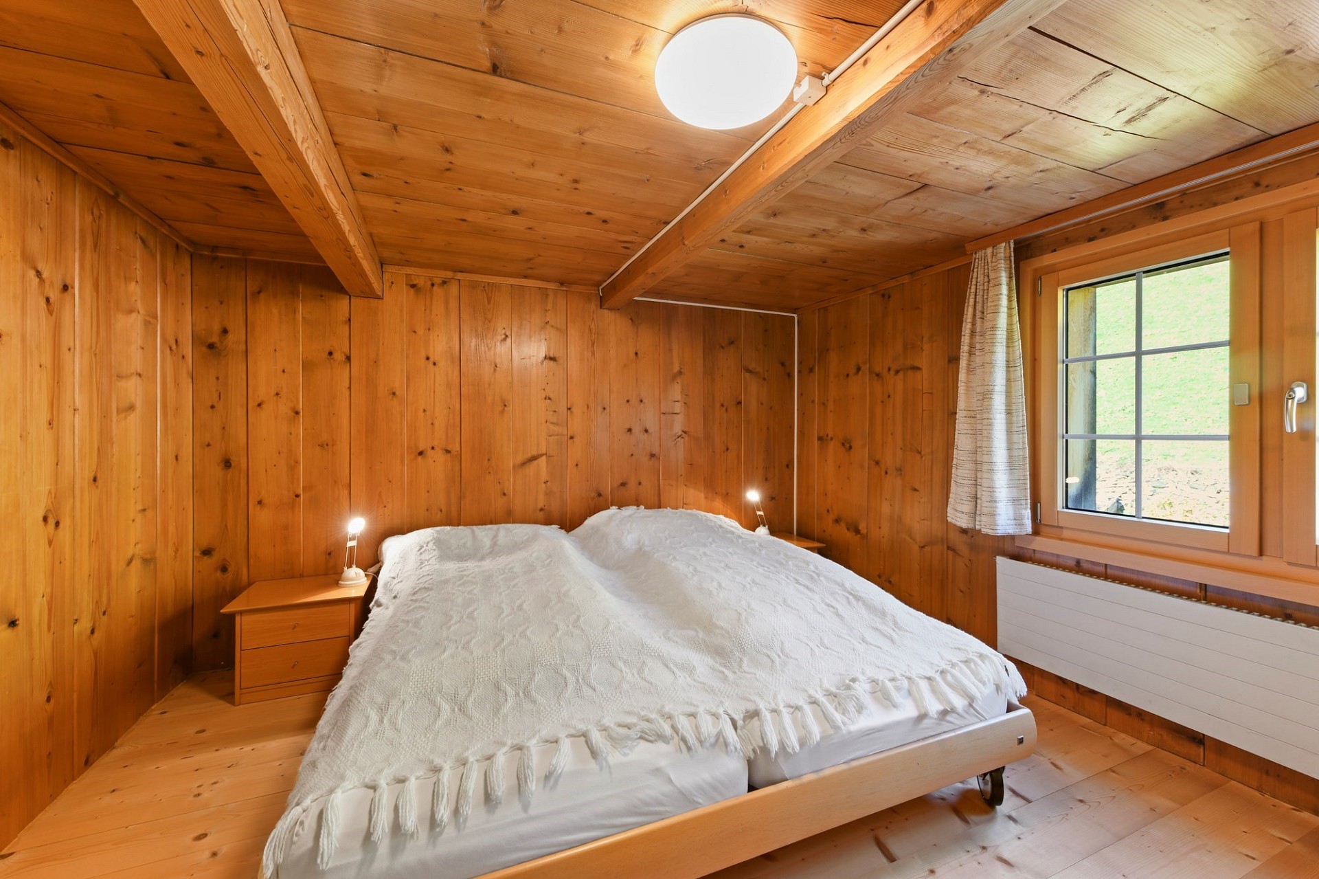 Holzverkleidetes Schlafzimmer mit Doppelbett