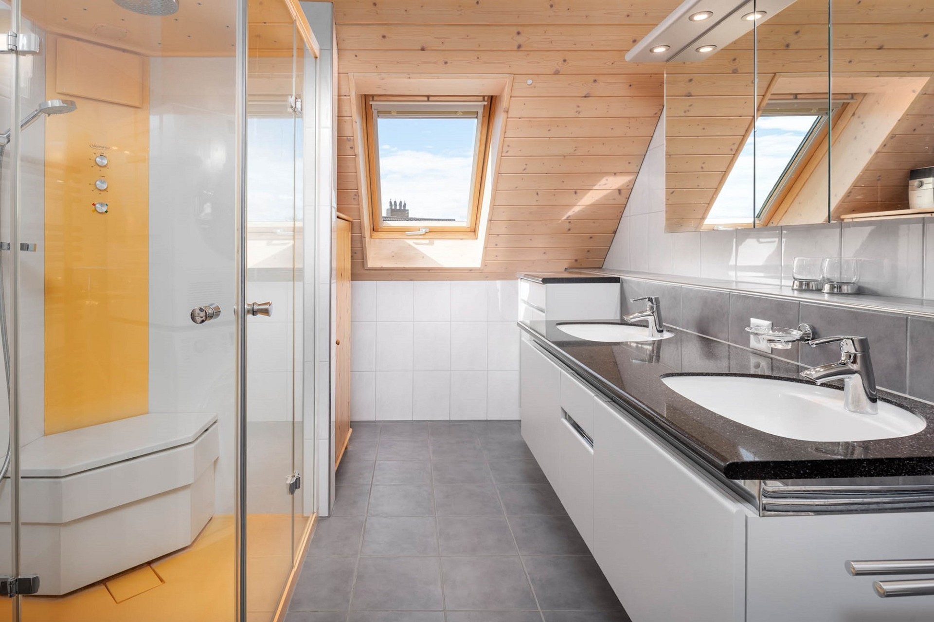 Helles Dachgeschoss-Badezimmer mit Sauna und Doppelwaschtisch
