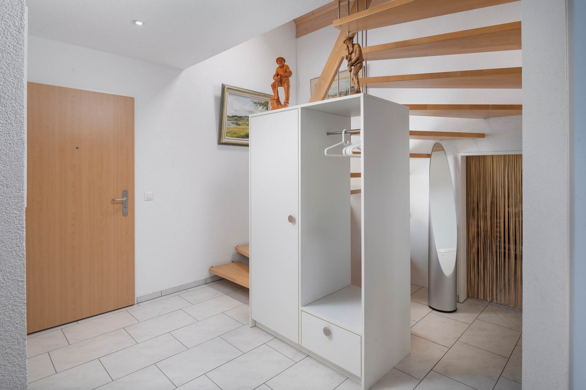 Heller Eingangsbereich mit Treppe und Garderobe