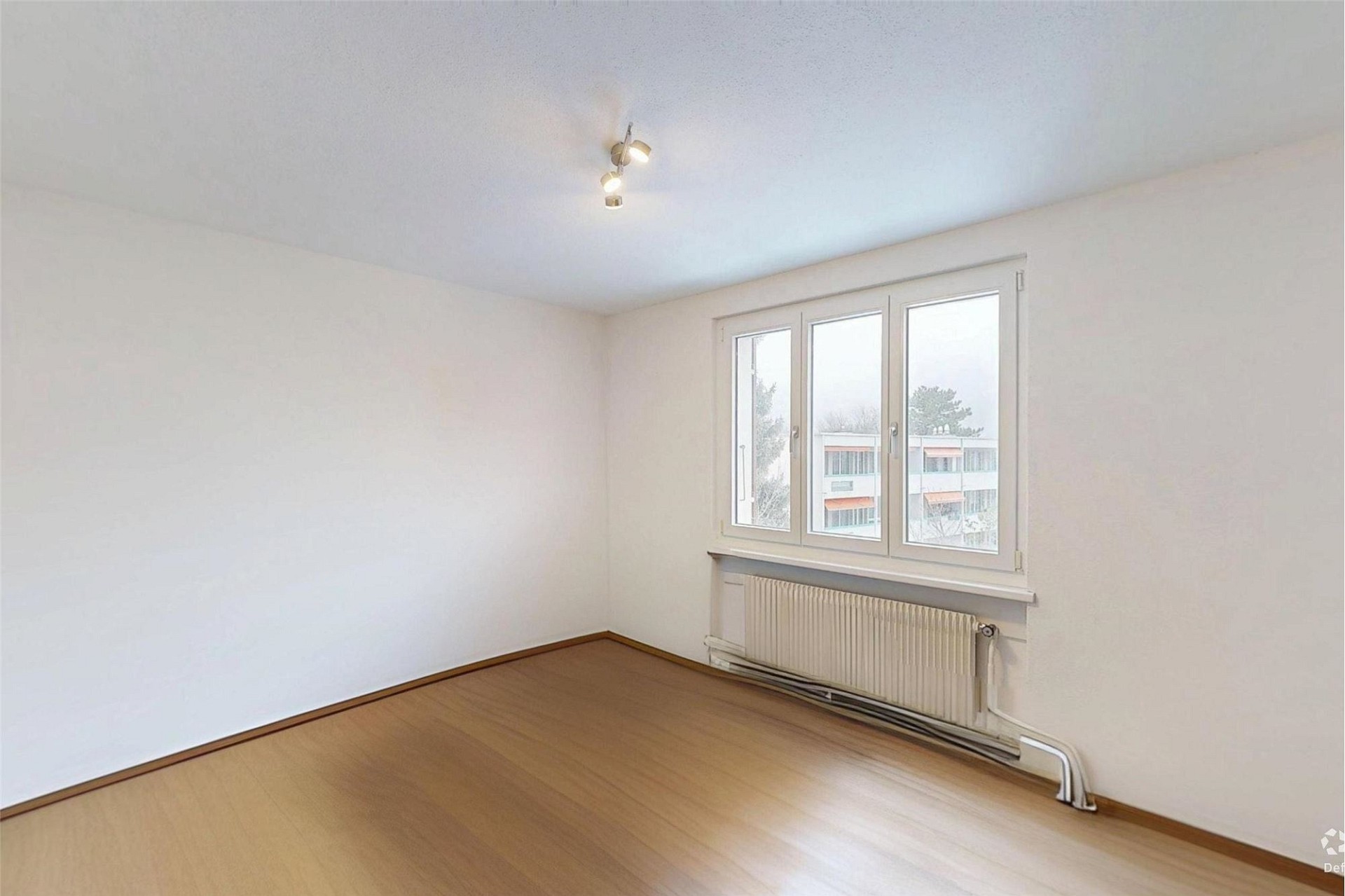 Heller leerer Wohnraum mit Fenster und Heizkörper