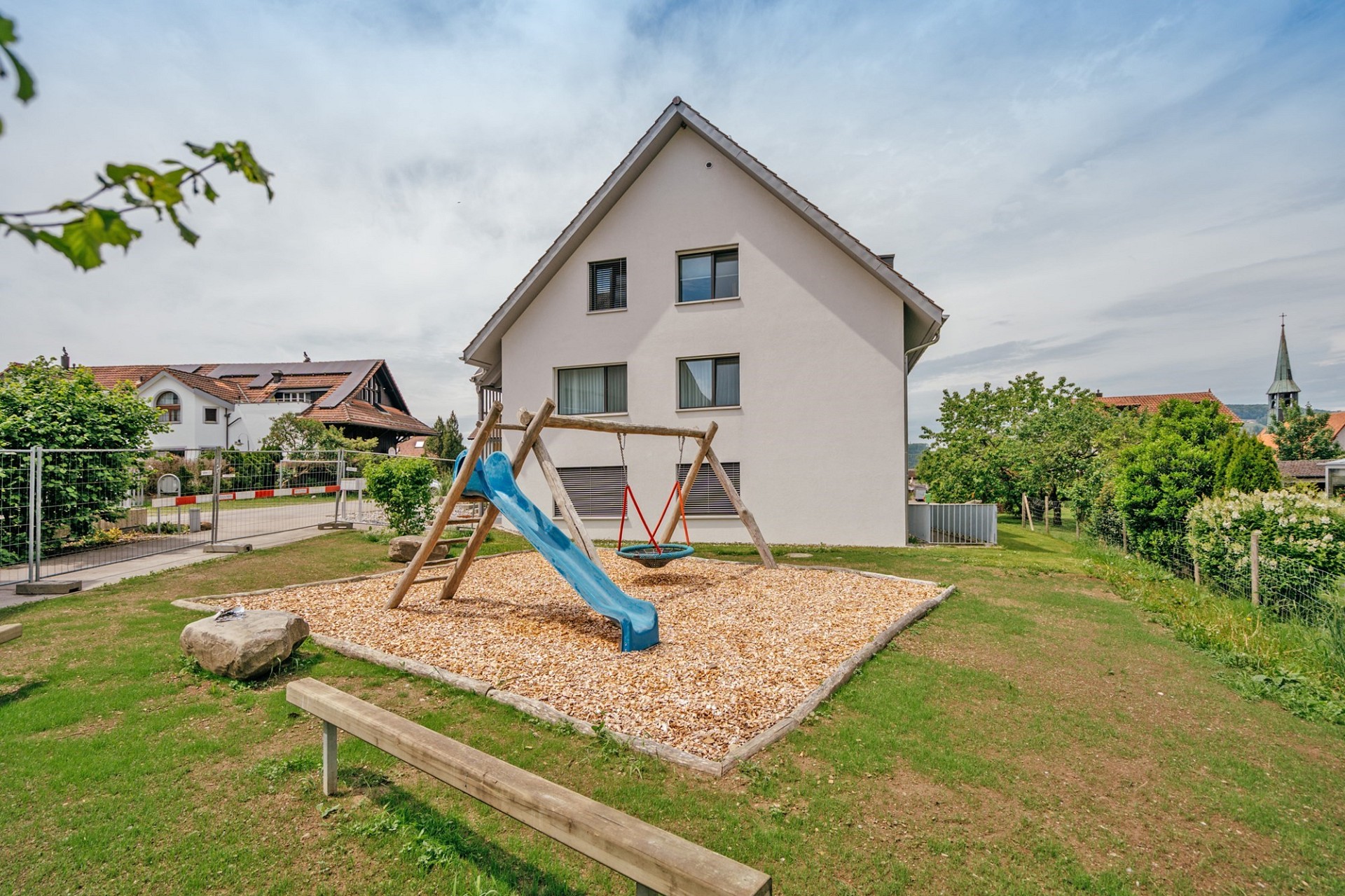 Außenansicht eines Hauses mit Spielplatz im Garten