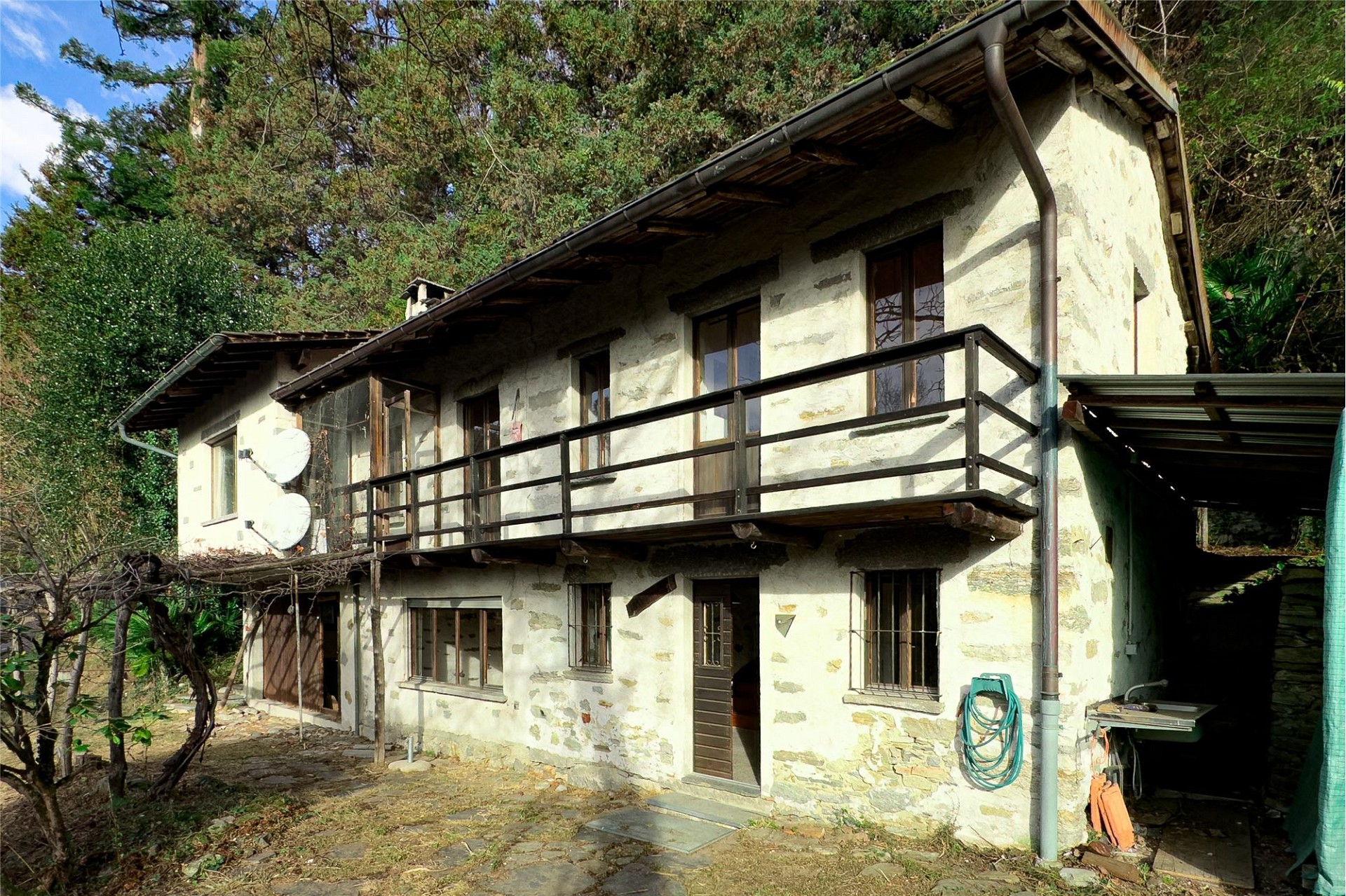 Bergiges Haus mit Balkon und verwitterter Fassade