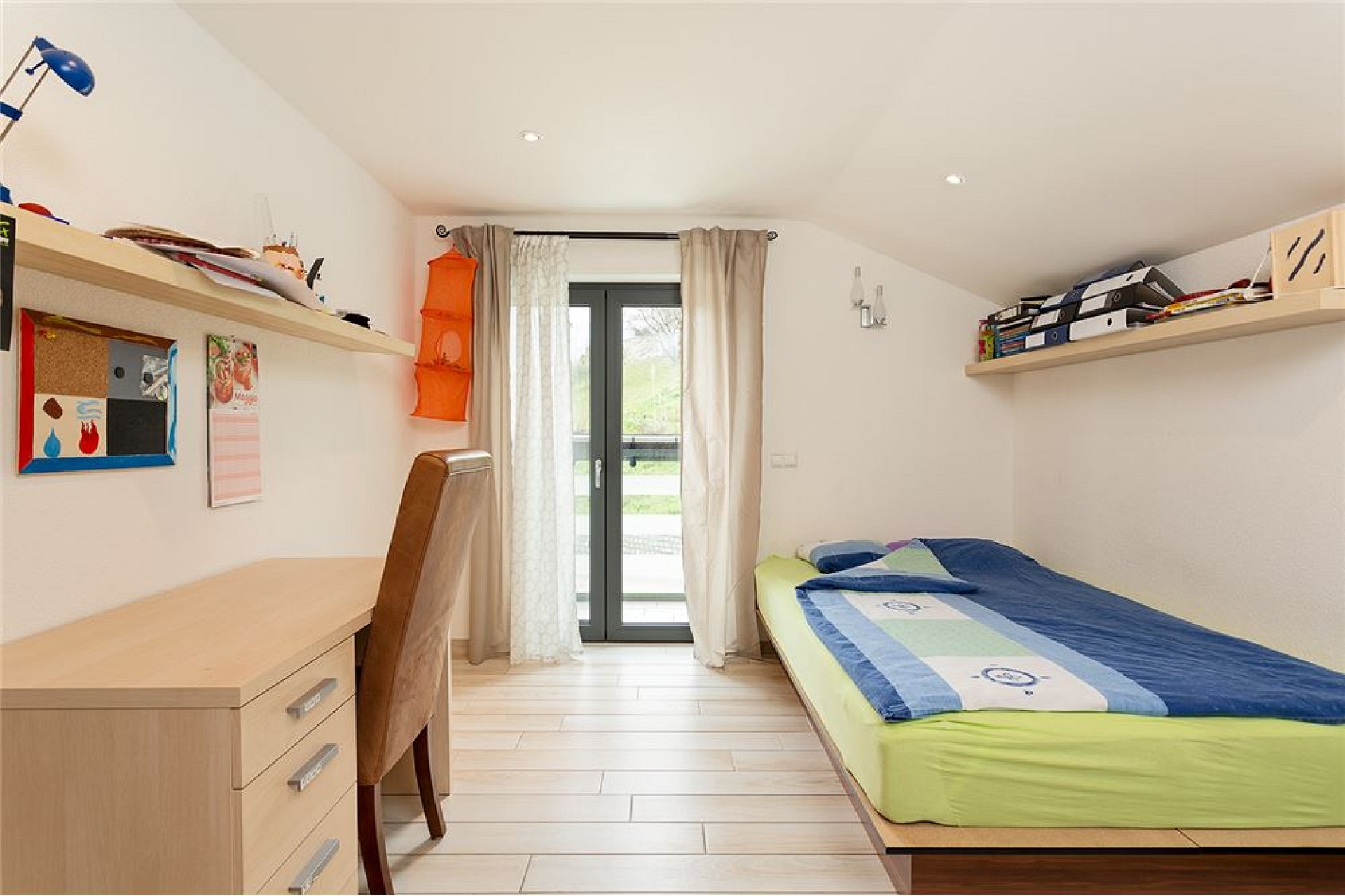 Helles Jugendzimmer mit Schreibtisch und Einzelbett