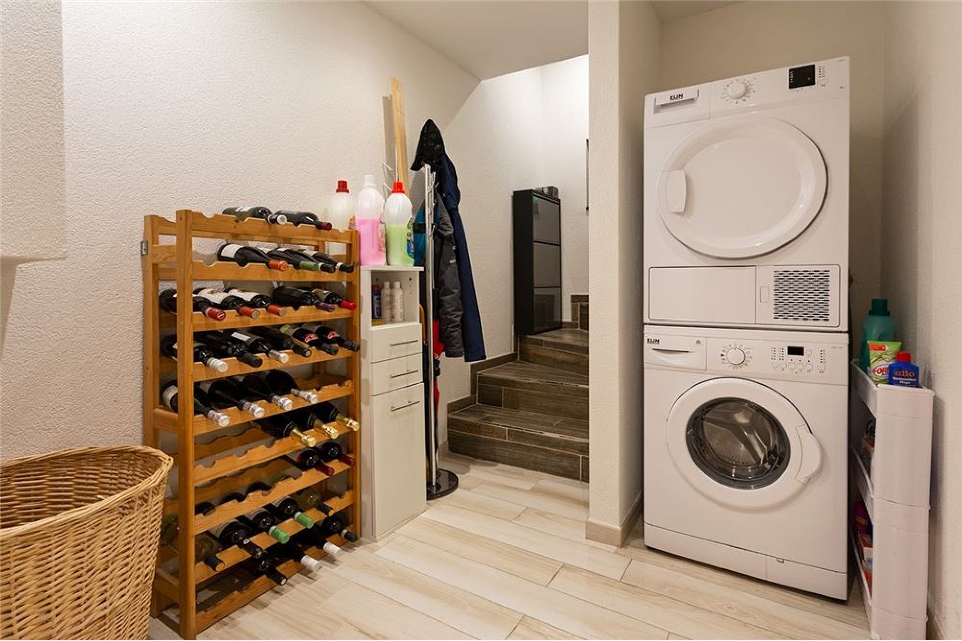 Hauswirtschaftsraum mit Wäschebereich und Weinkellerregal