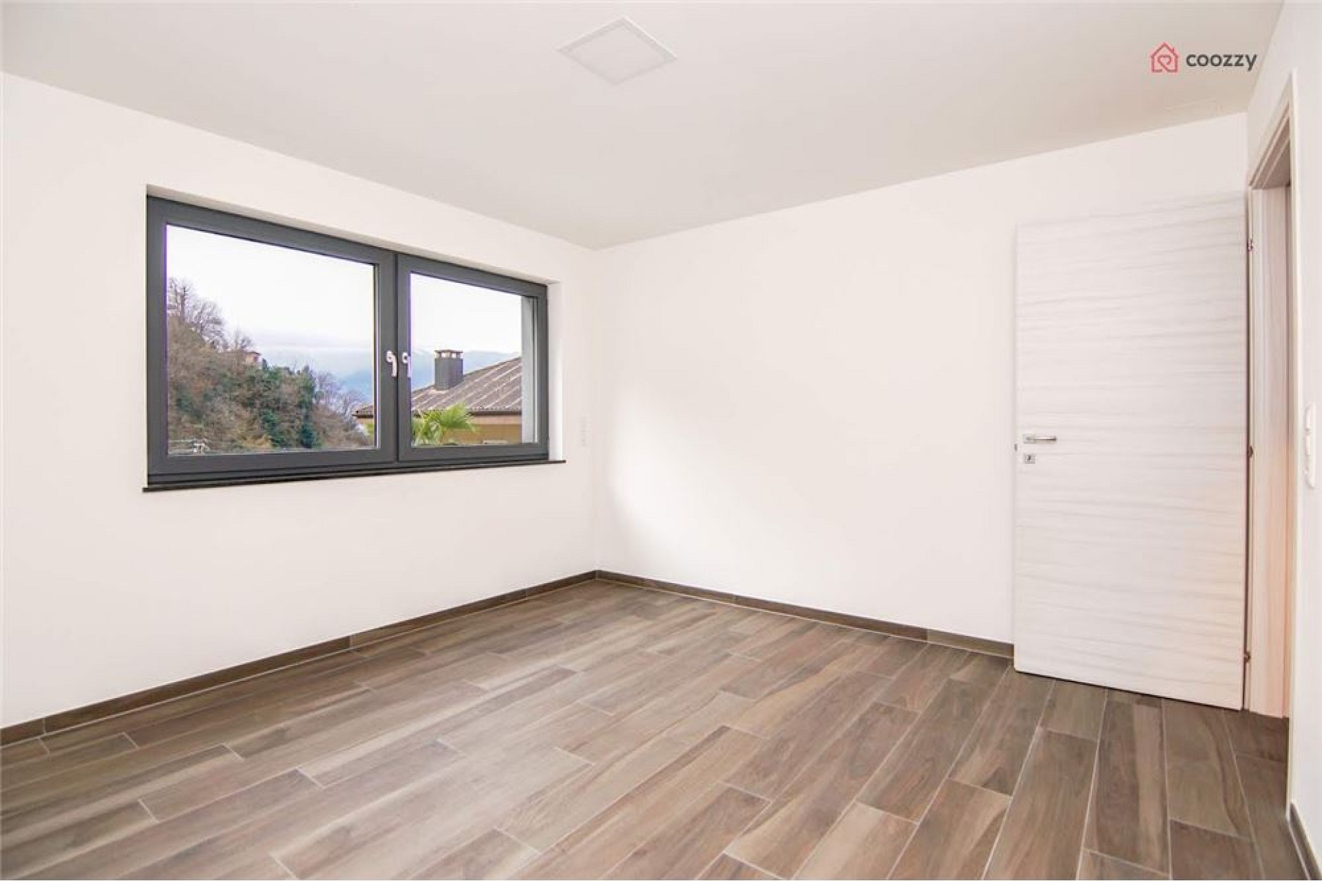 Leeres, modern gestaltetes Zimmer mit Fenster und Tür