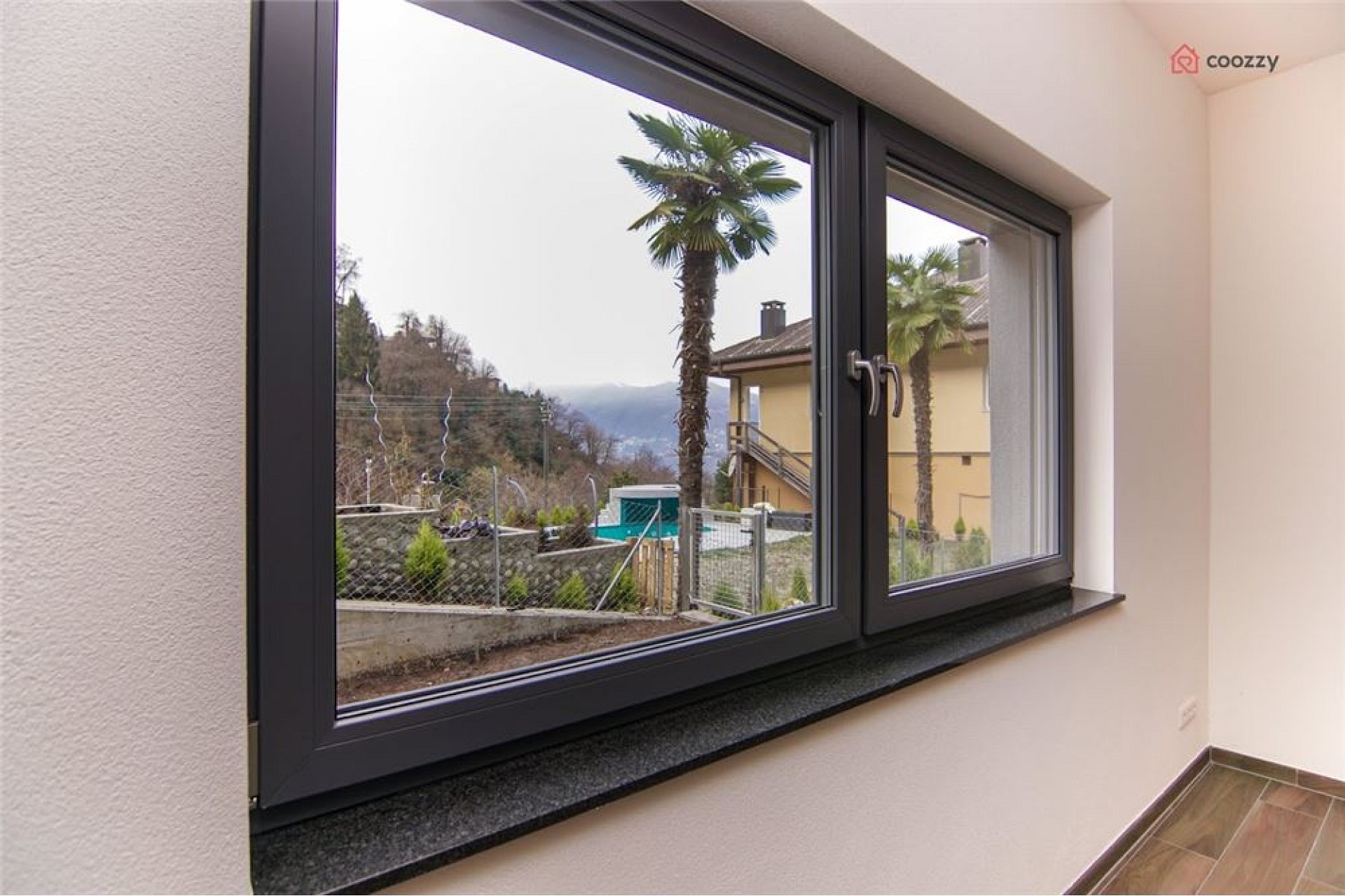 Innenraum mit großem Fenster und Bergblick