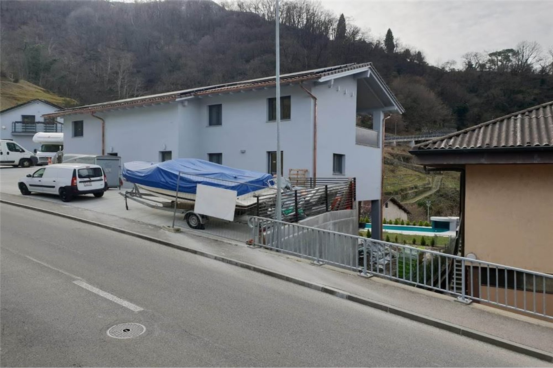 Wohnhaus an Hanglage mit Straße im Vordergrund