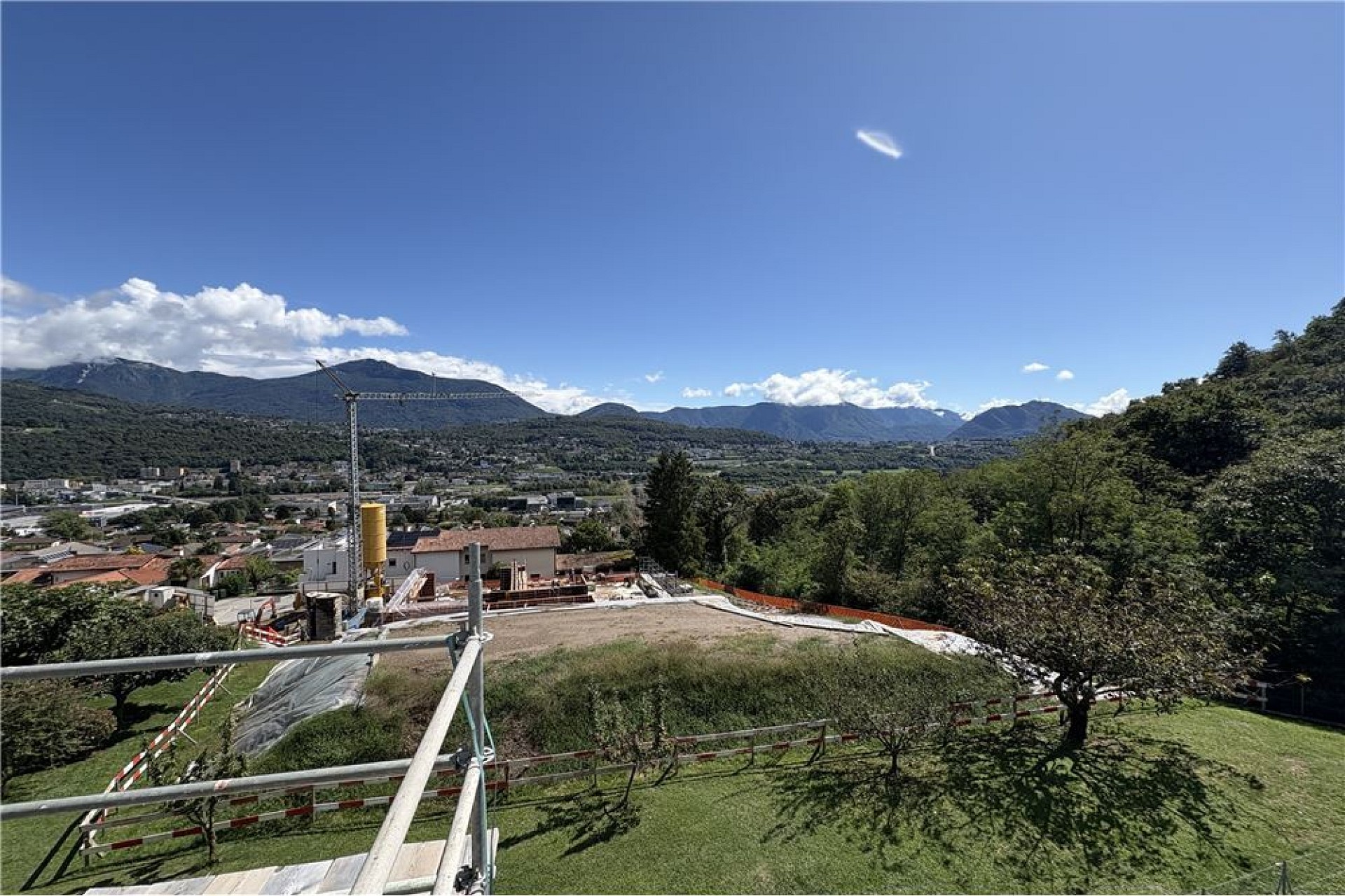 Bergblick über eine Baustelle und grüne Hanglage