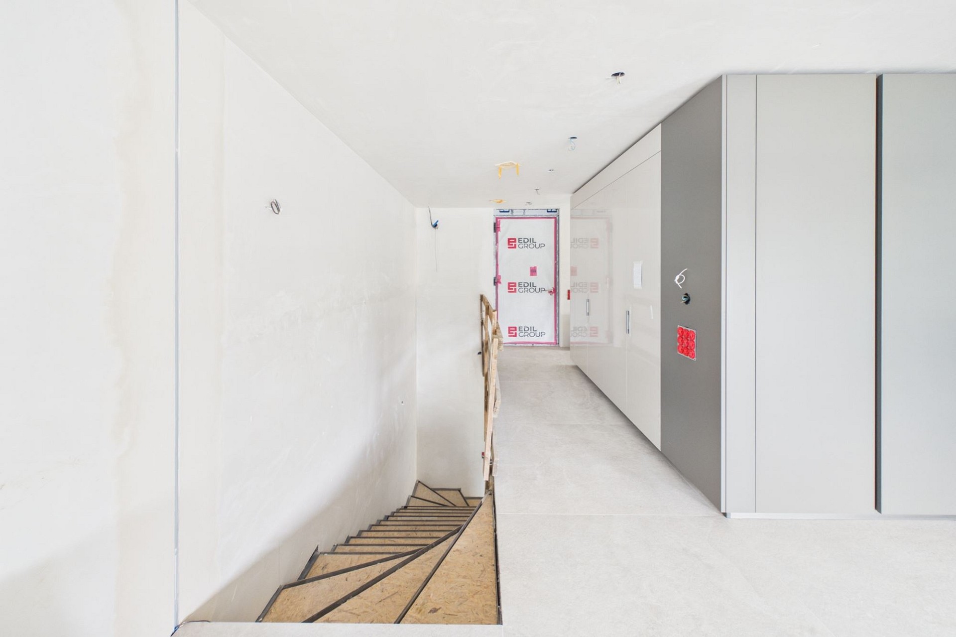 Heller Flur mit Treppe und Einbauschränken im Ausbau