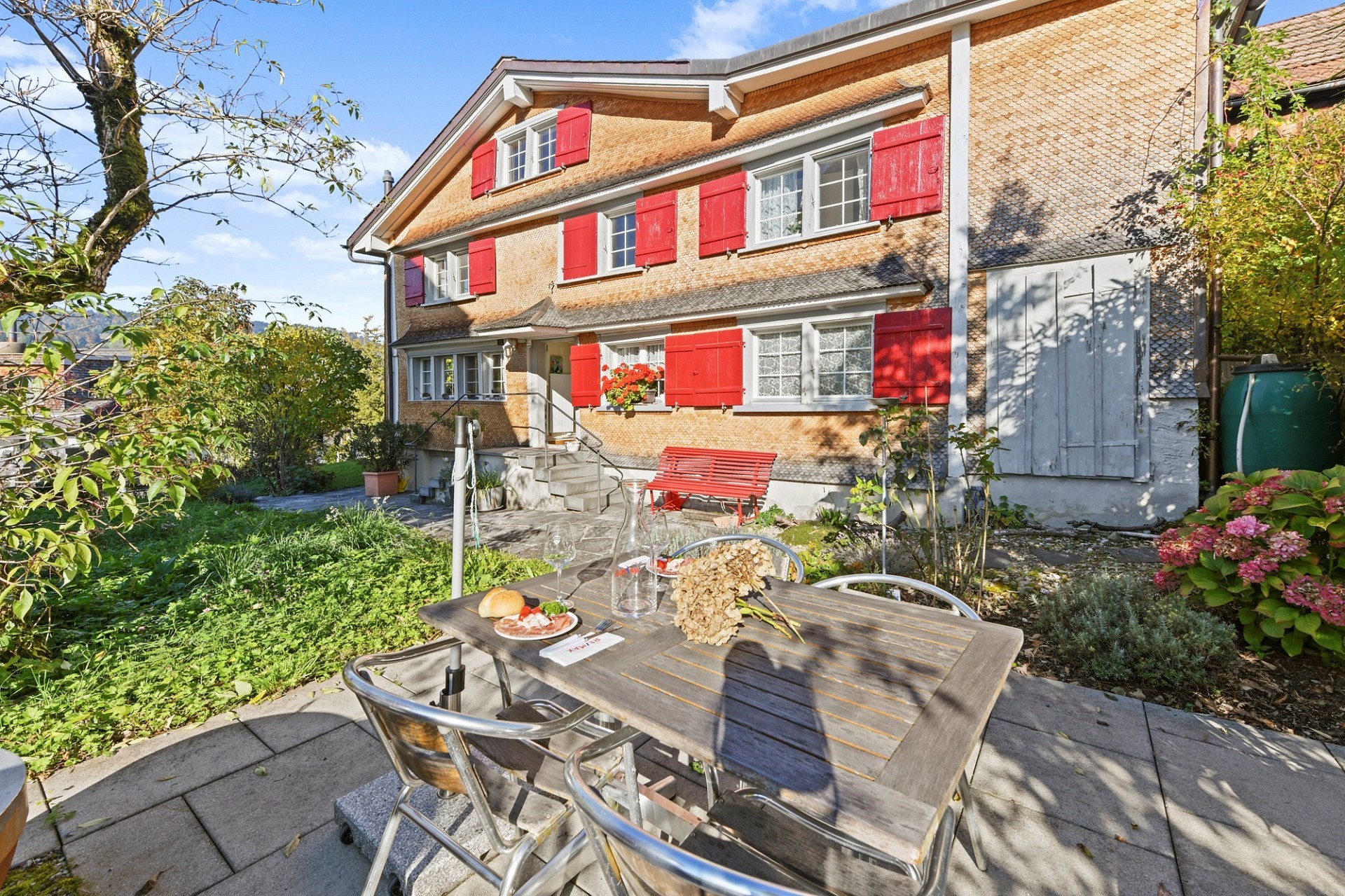 Gartenansicht eines rustikalen Hauses mit Terrasse