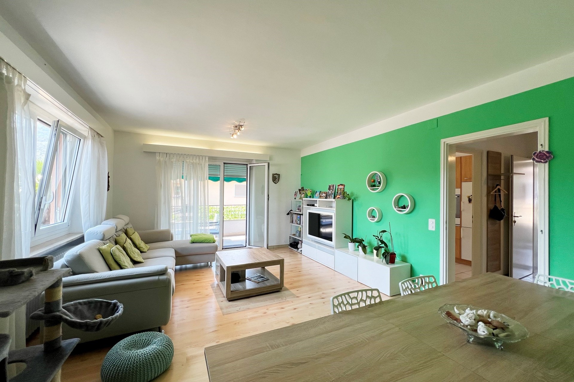 Helles Wohnzimmer mit grün akzentuierter Wand