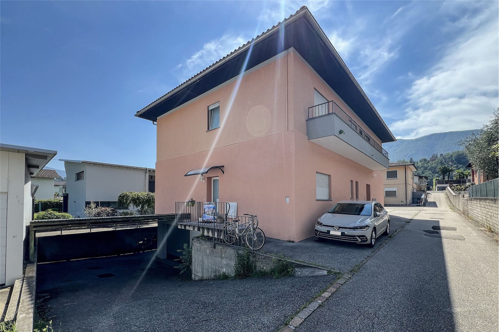 Außenansicht eines Wohnhauses mit Balkon und Carport