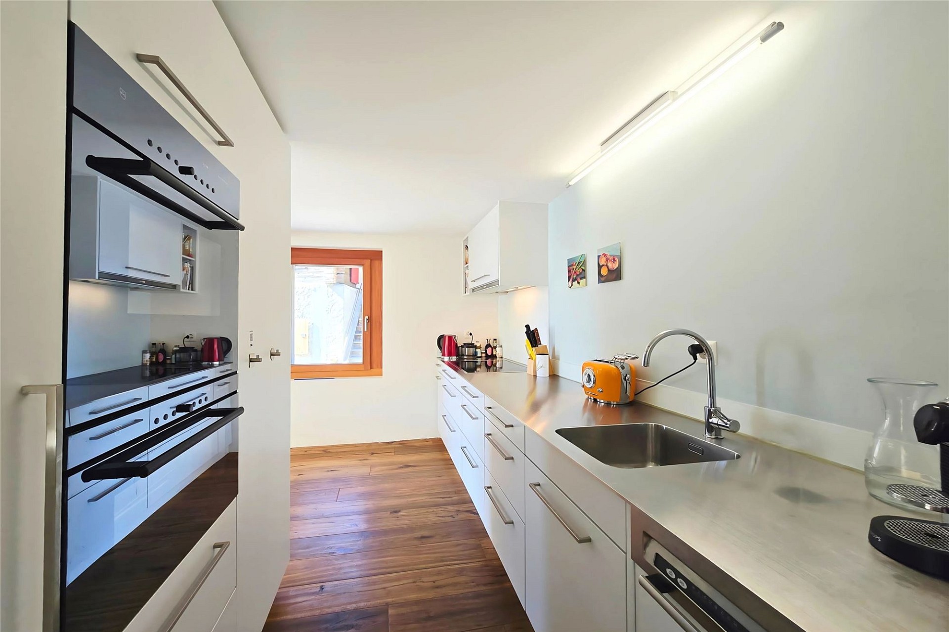 Moderne schmale Küche mit Holzfußboden