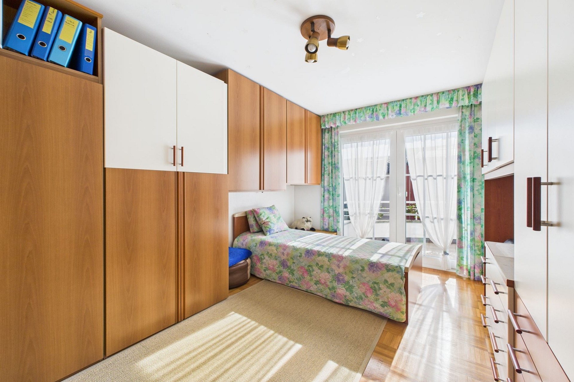 Kleines Schlafzimmer mit Einbauschränken und Balkonzugang