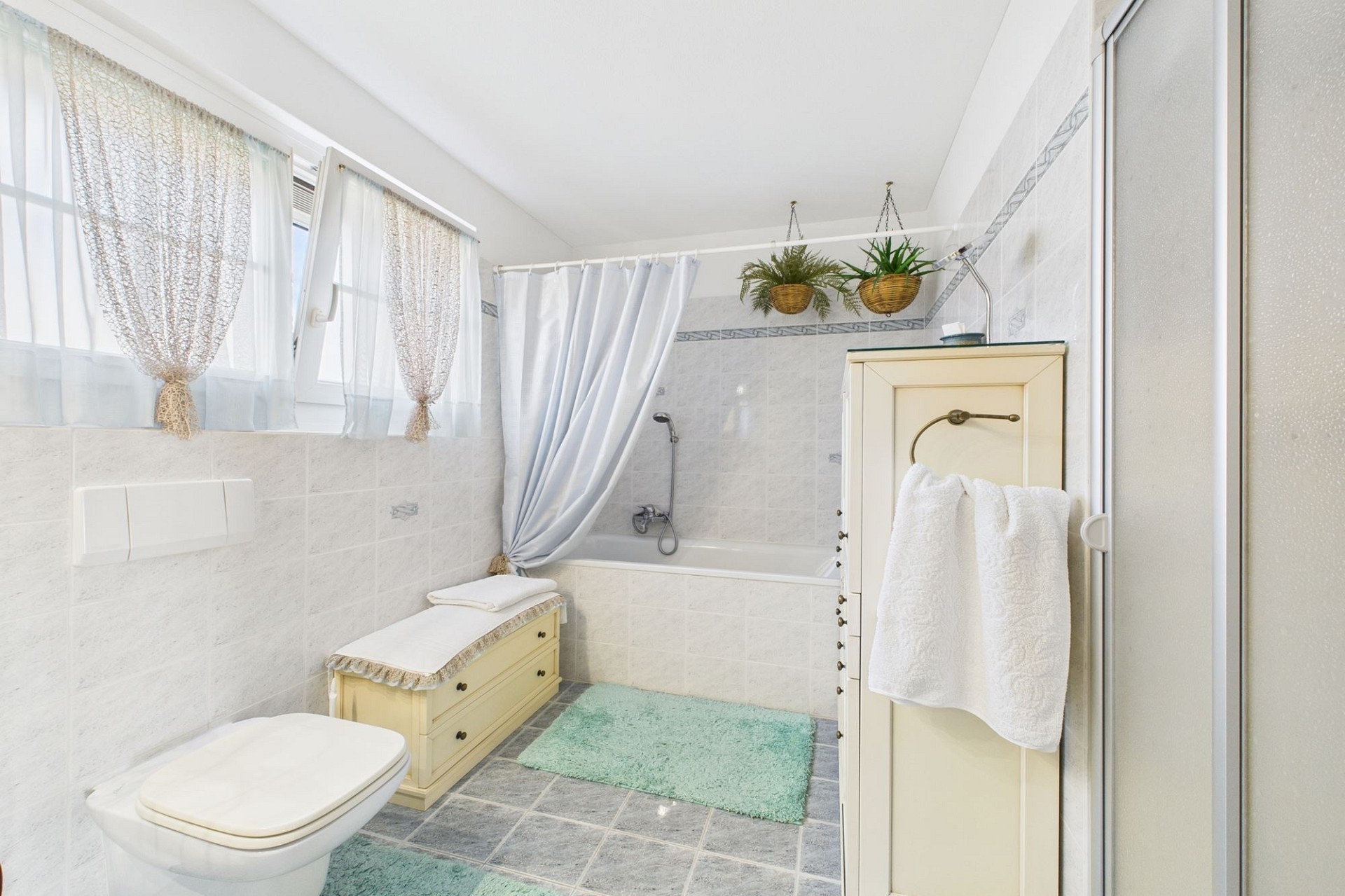 Helles, gepflegtes Badezimmer mit Badewanne und Toilette