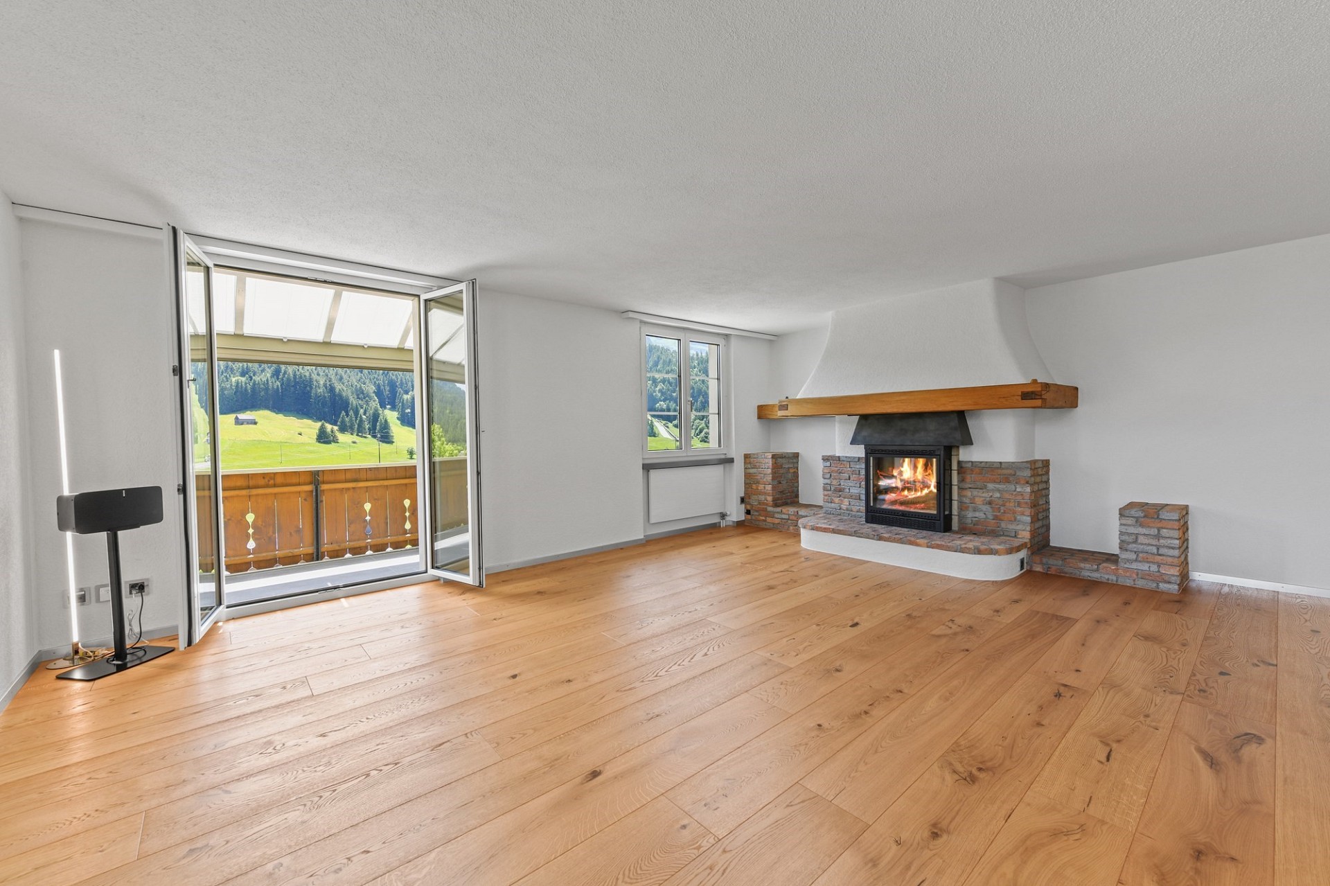 Heller Wohnraum mit Kamin und Bergblick