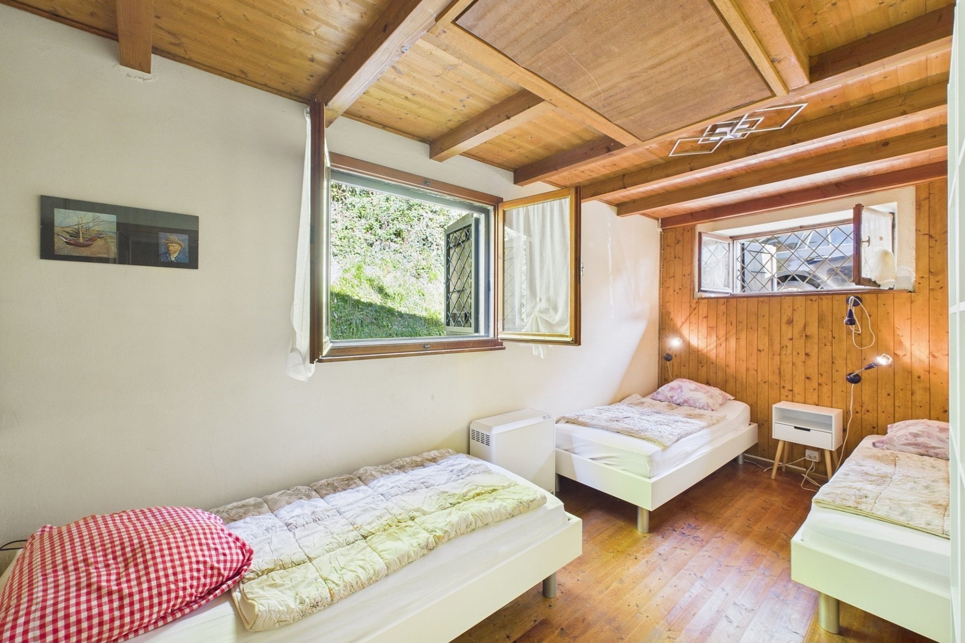 Schlafzimmer mit drei Betten und Holzbalkendecke