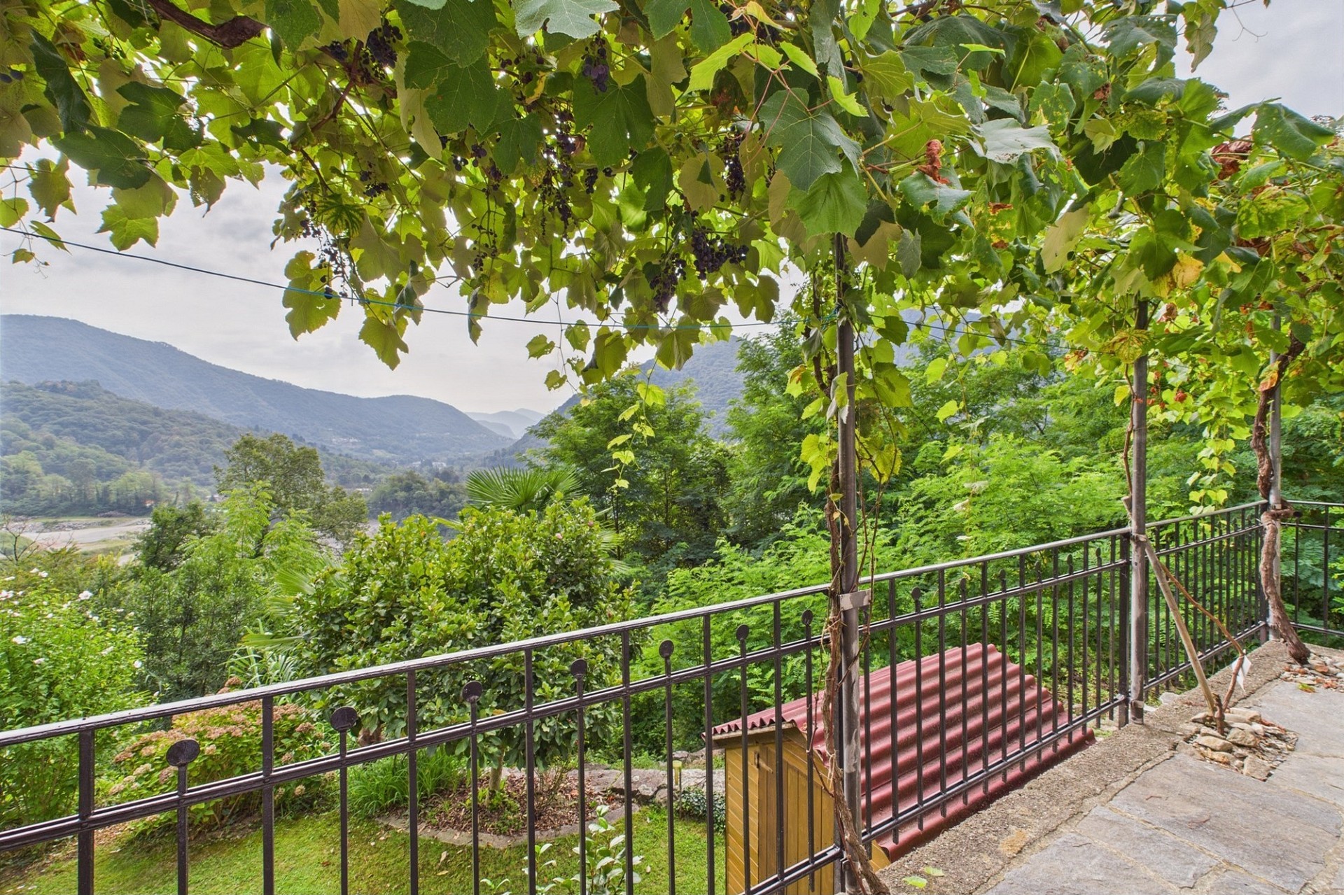 Blick von einer Terrasse in ein grünes Tal