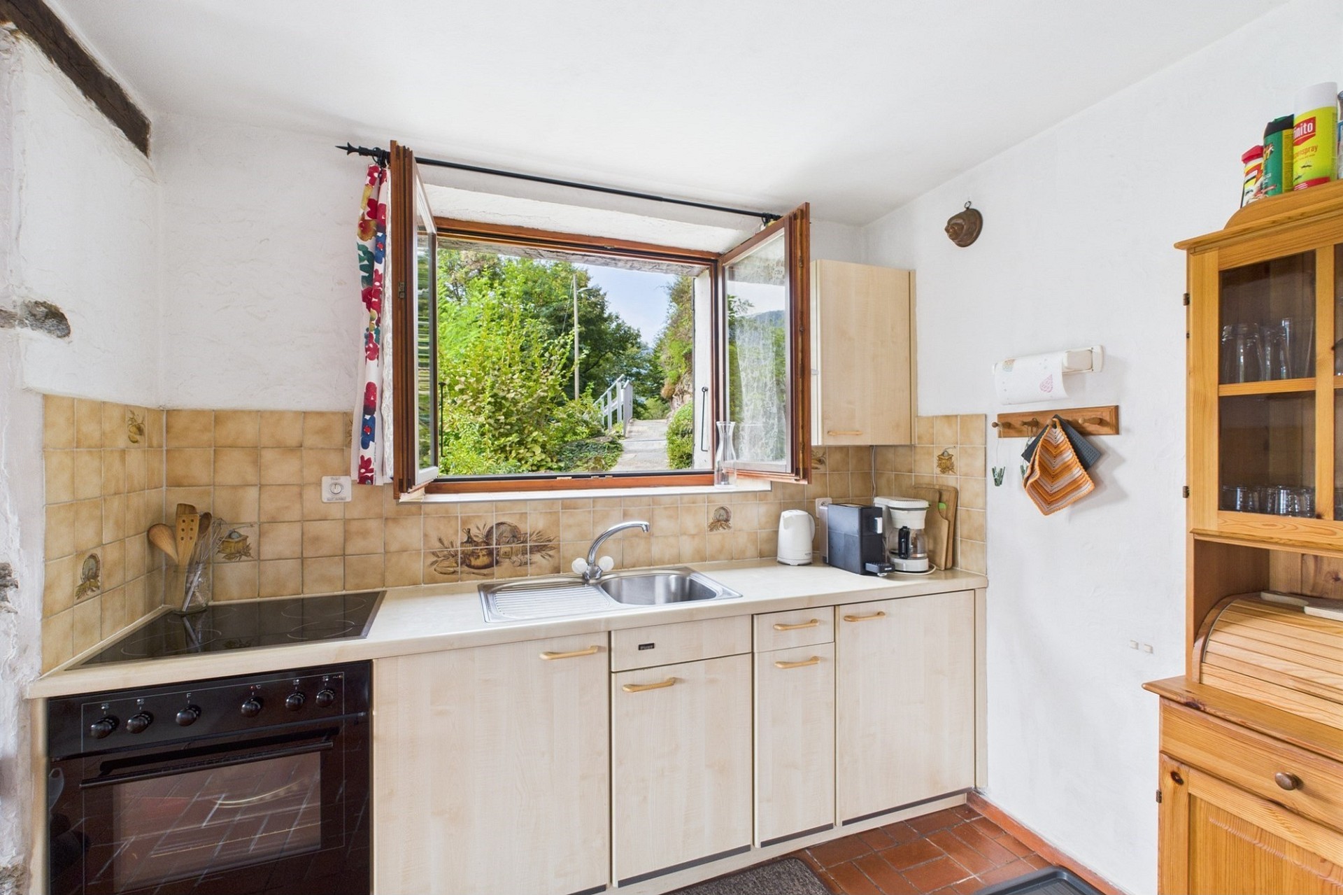 Kleine Küche mit geöffnetem Fenster und Gartenblick