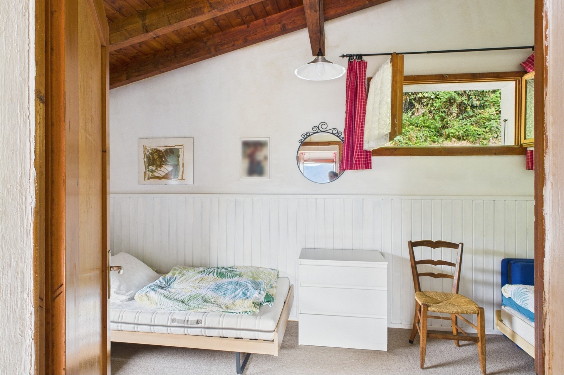 Gemütliches Dachzimmer mit zwei Betten und Blick ins Grüne