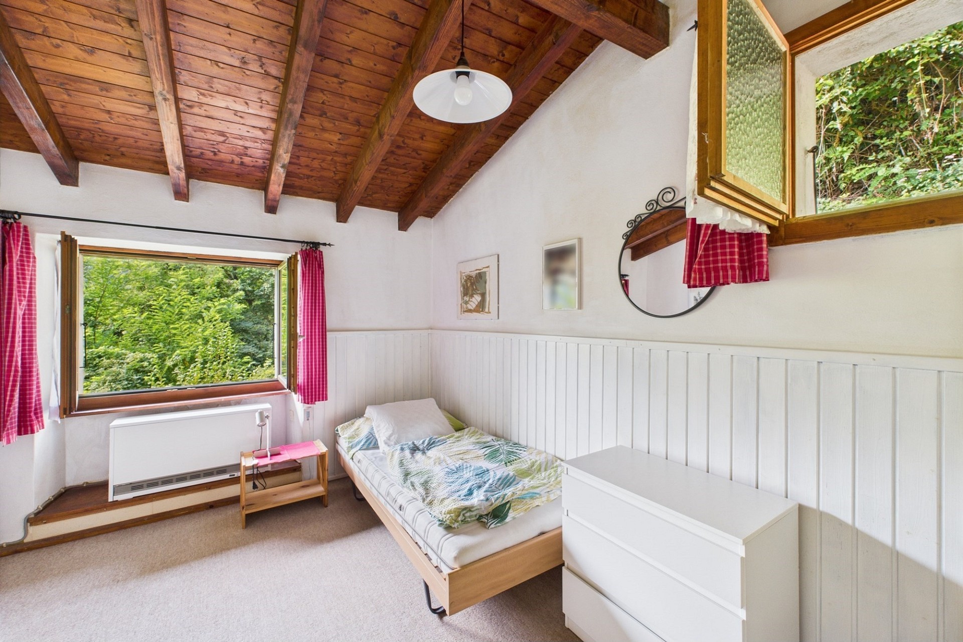 Gemütliches Schlafzimmer mit Holzdecke und Gartenblick