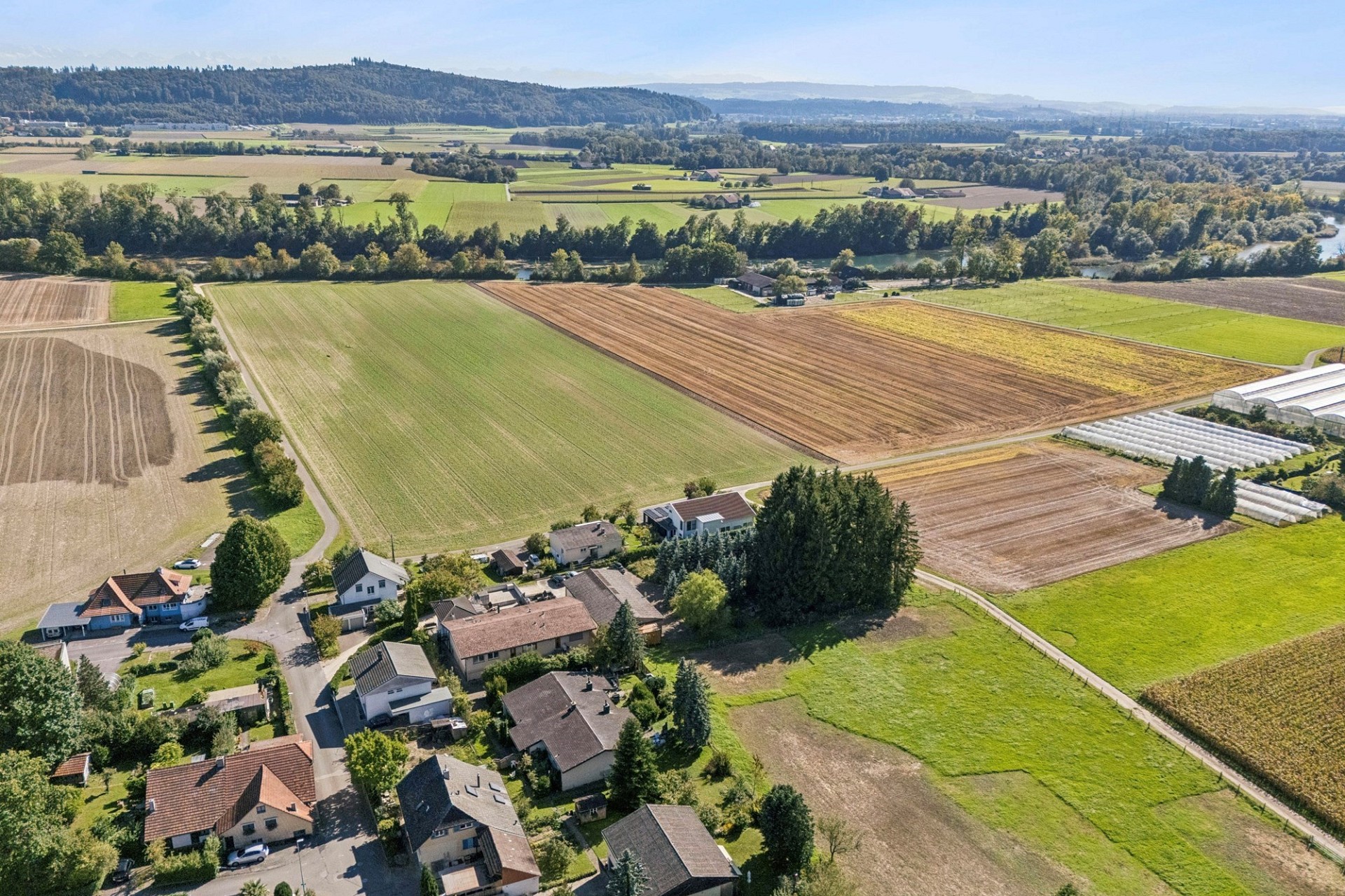 Luftaufnahme einer ländlichen Siedlung mit Ackerflächen