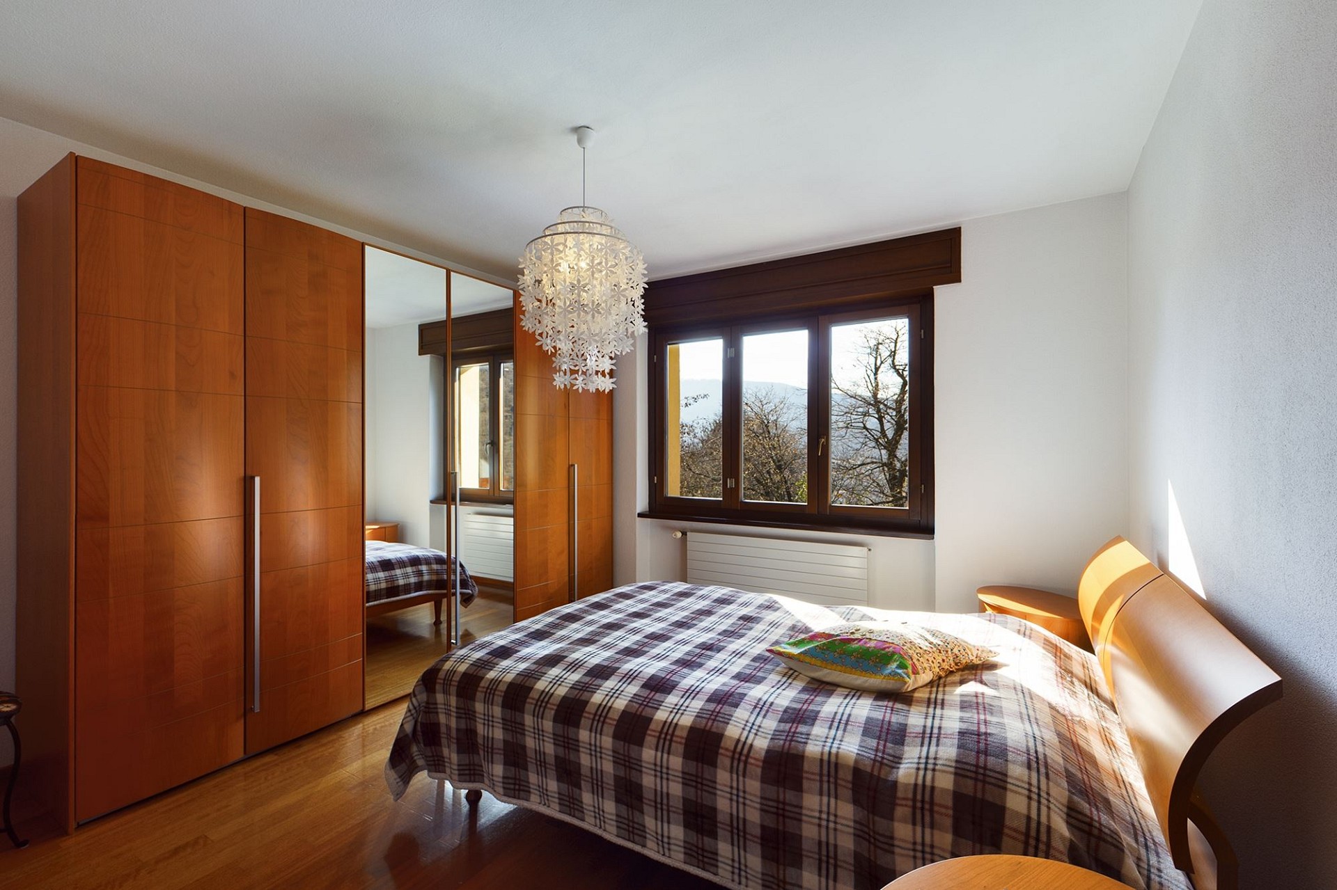 Schlafzimmer mit Einbauschrank und Fensterblick