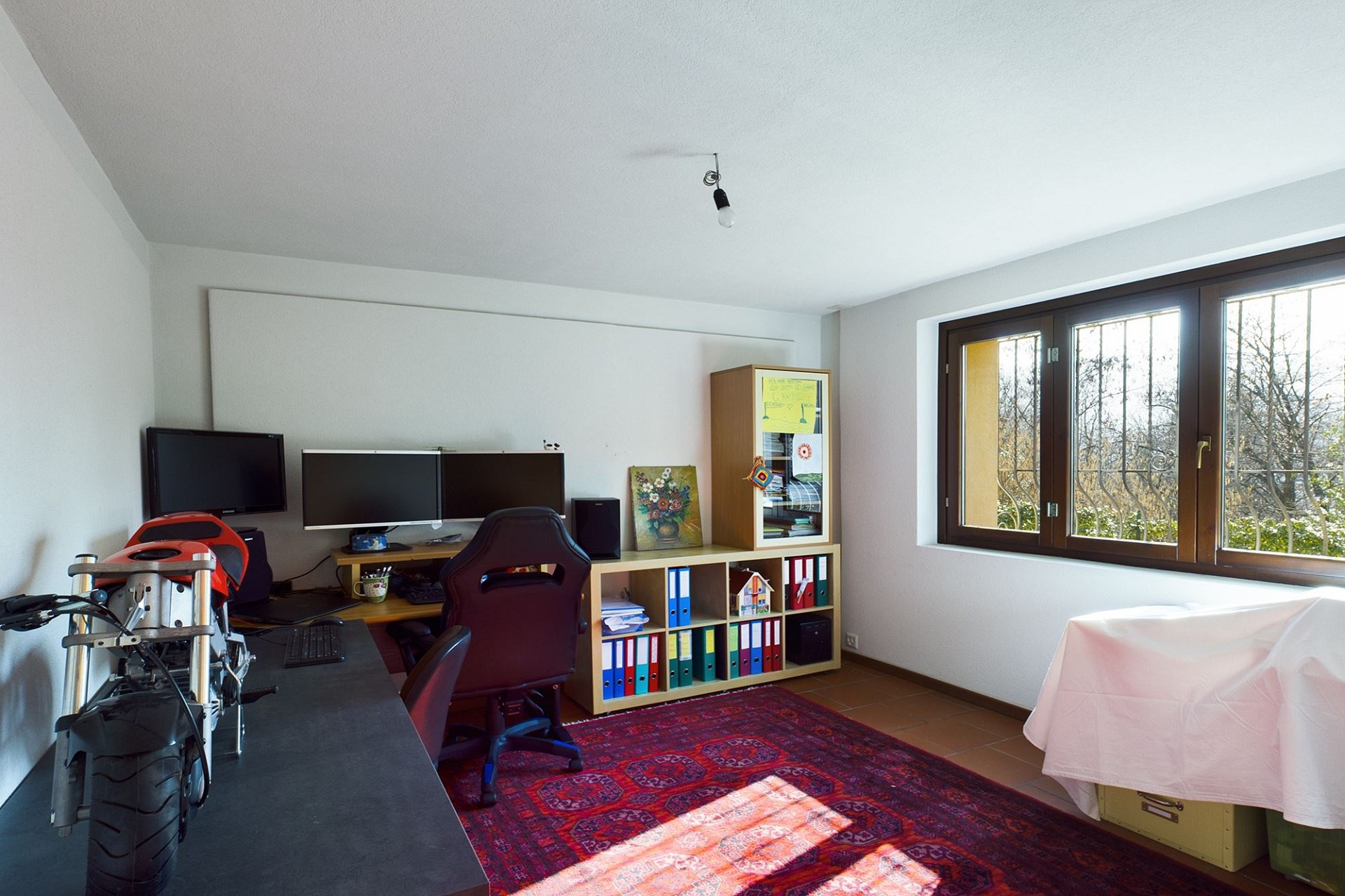 Helles Arbeitszimmer mit Schreibtisch und großem Fenster