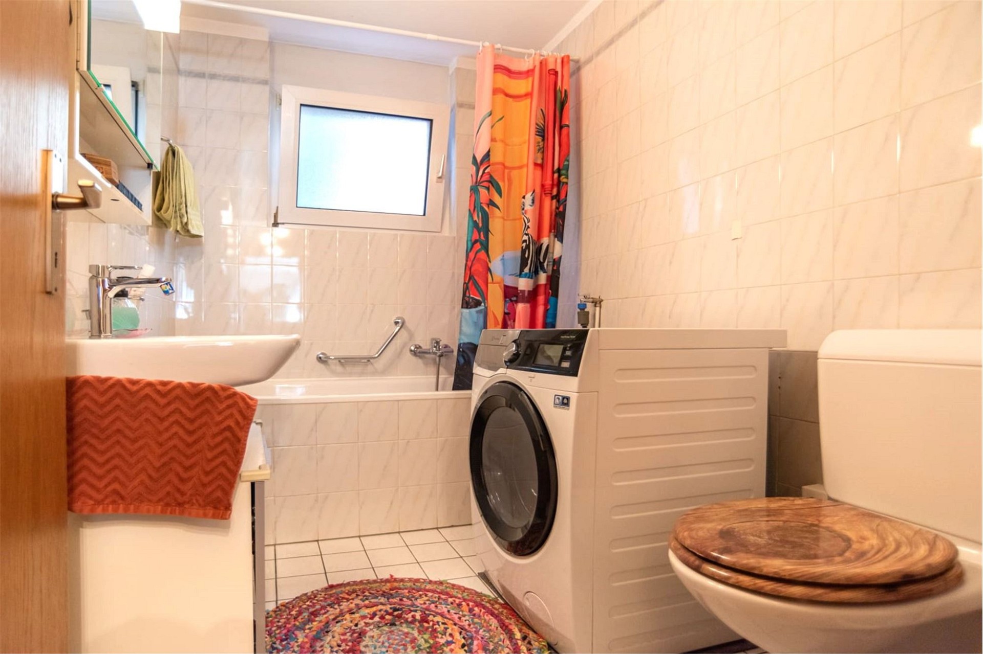 Badezimmer mit Waschmaschine und Wanne