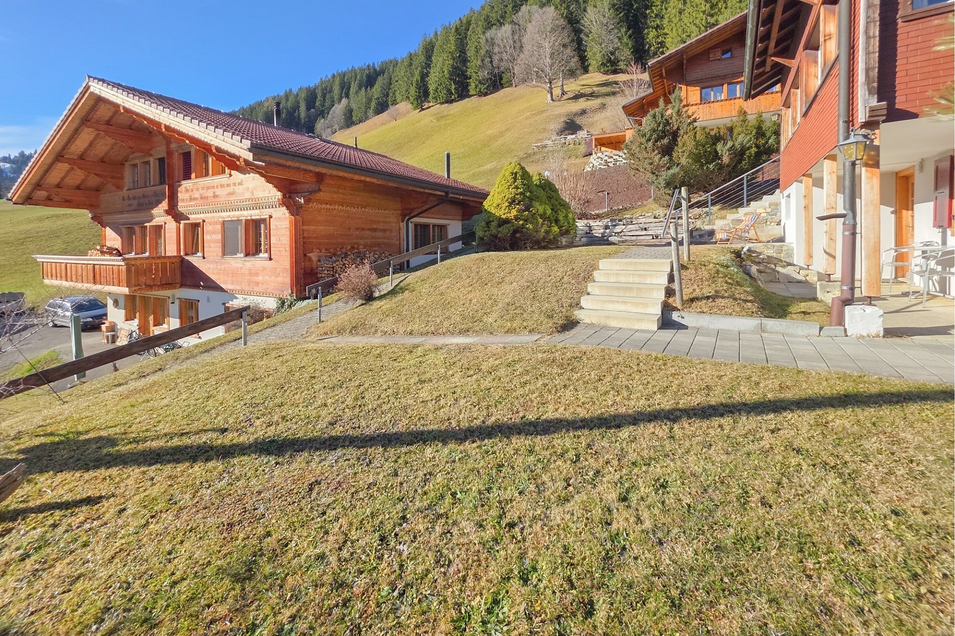 Alpines Holzhaus mit Hanglage und Blick auf die Berge