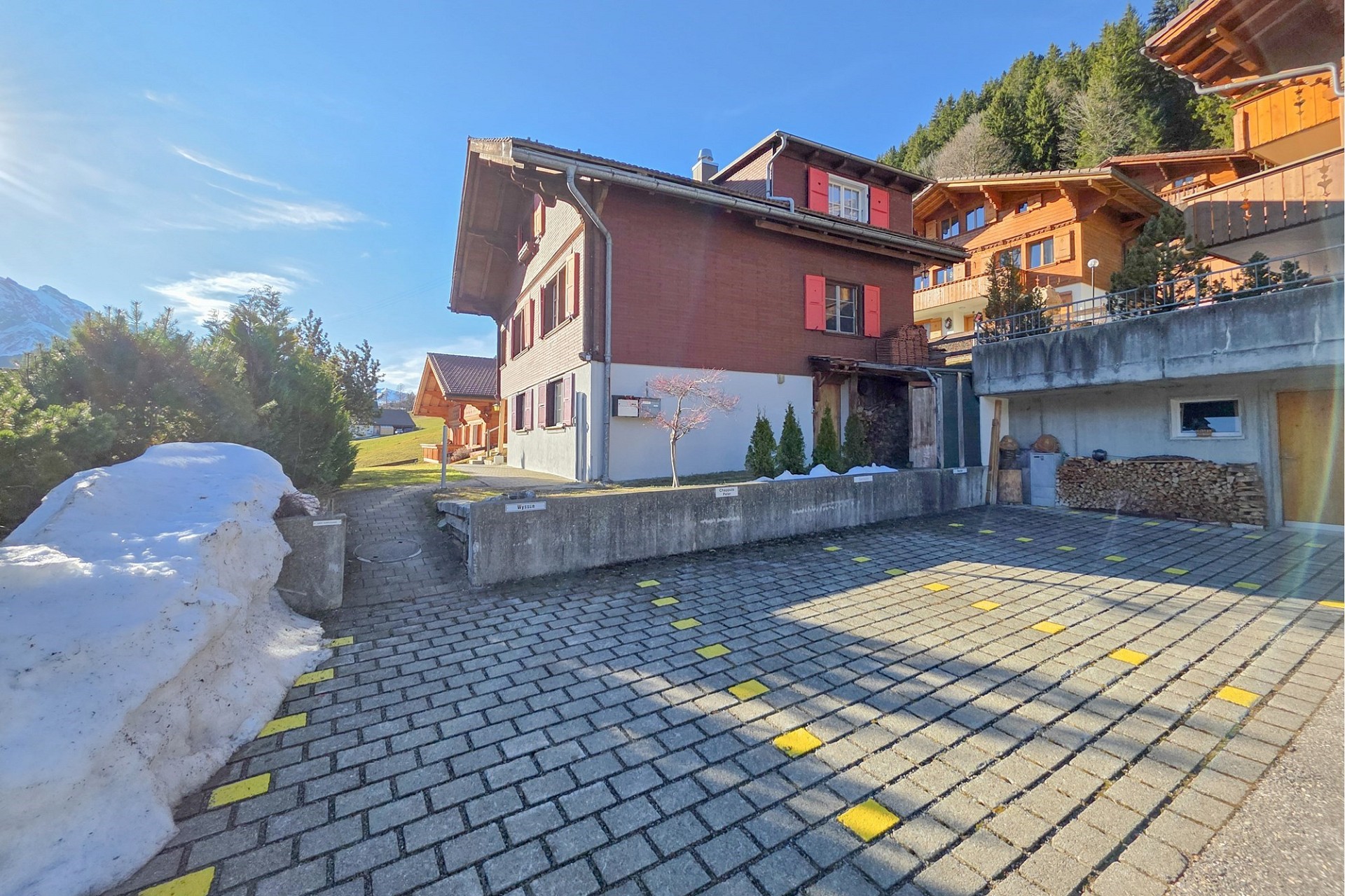 Alpenhaus mit Zufahrt und verschneitem Umfeld