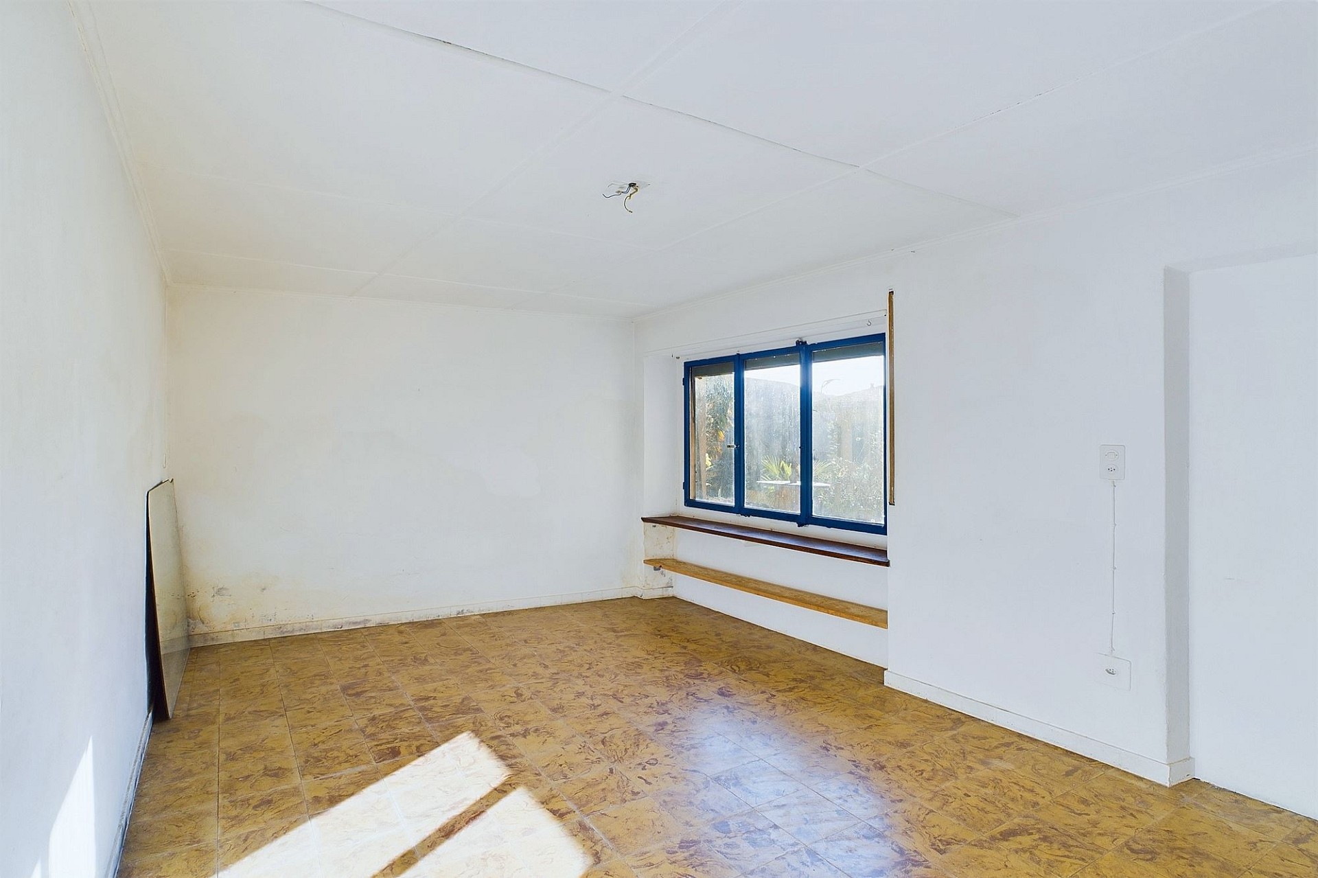 Leerer Raum mit blau gerahmtem Fenster