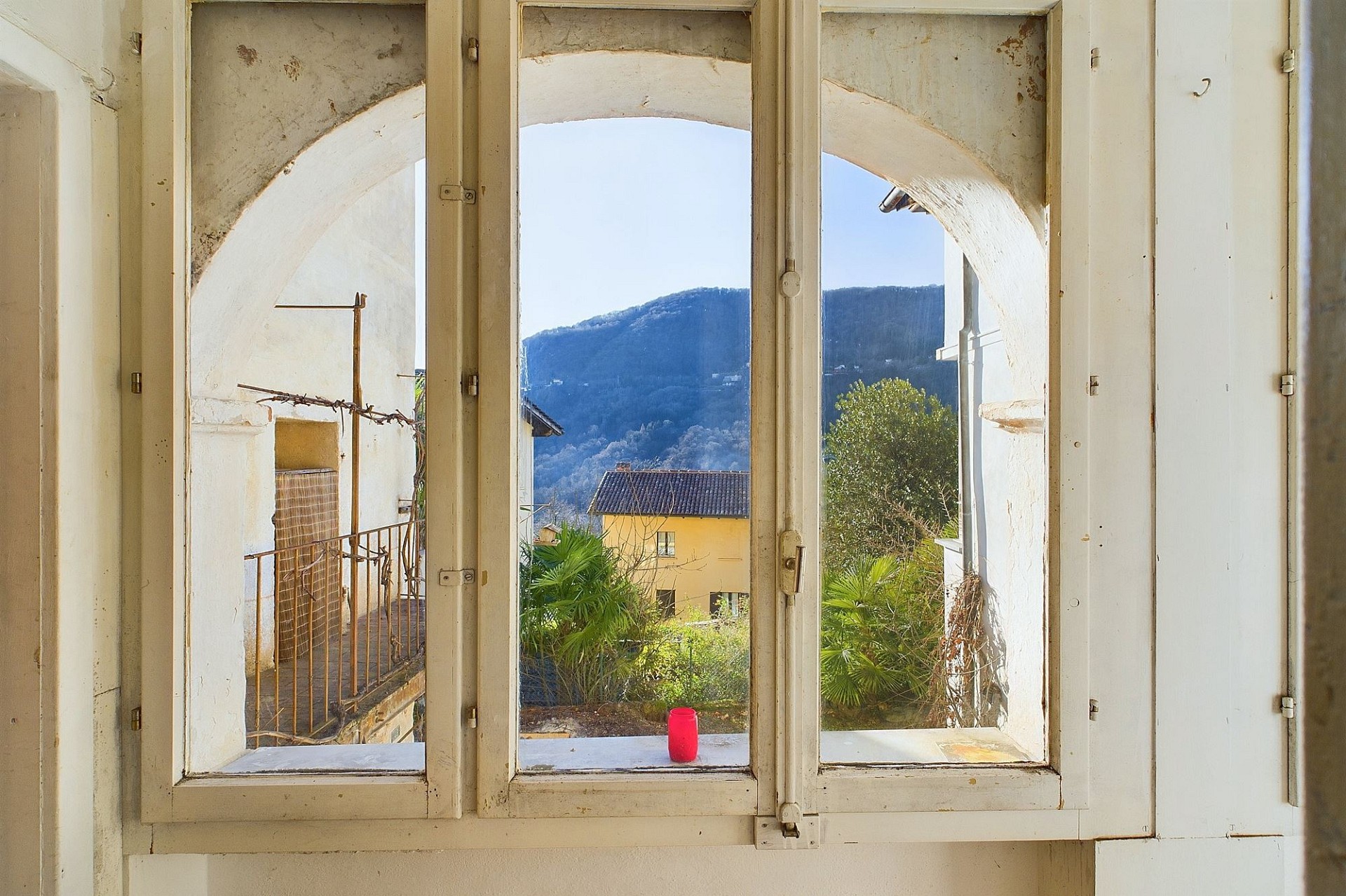 Fenster mit Rundbogen und Bergblick