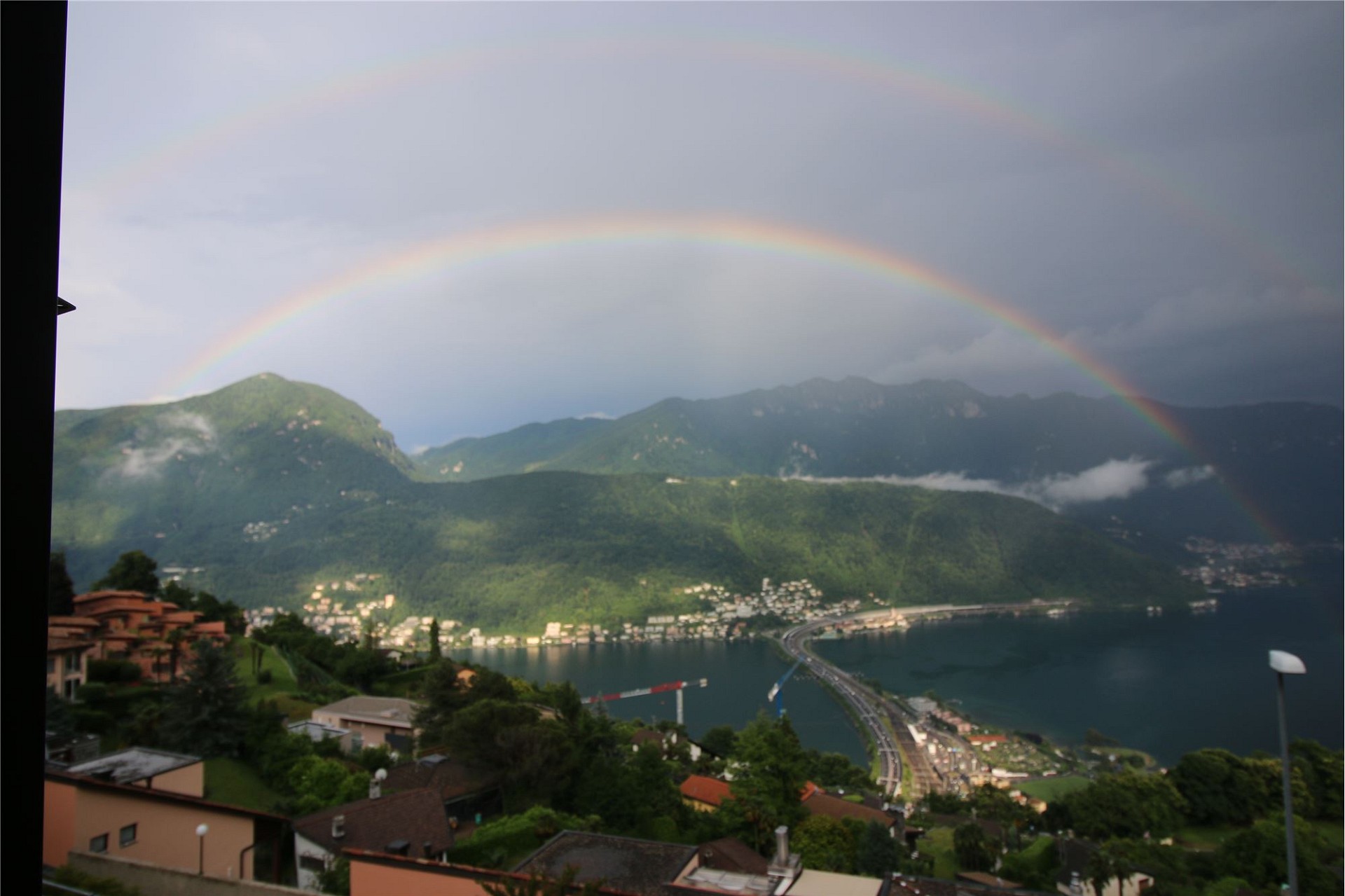 Regenbogen über See und Bergen