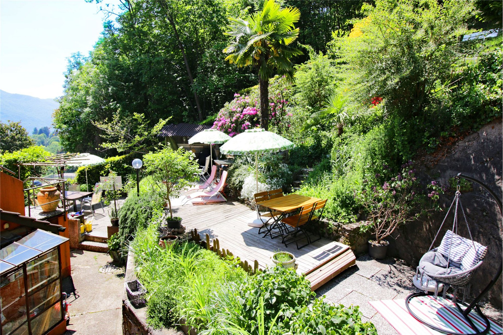 Üppig begrünte Gartenterrasse mit Sitz- und Essbereichen
