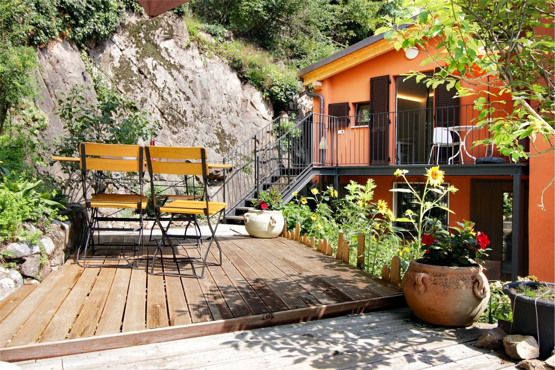 Außenansicht einer Terrasse mit orangefarbener Fassade
