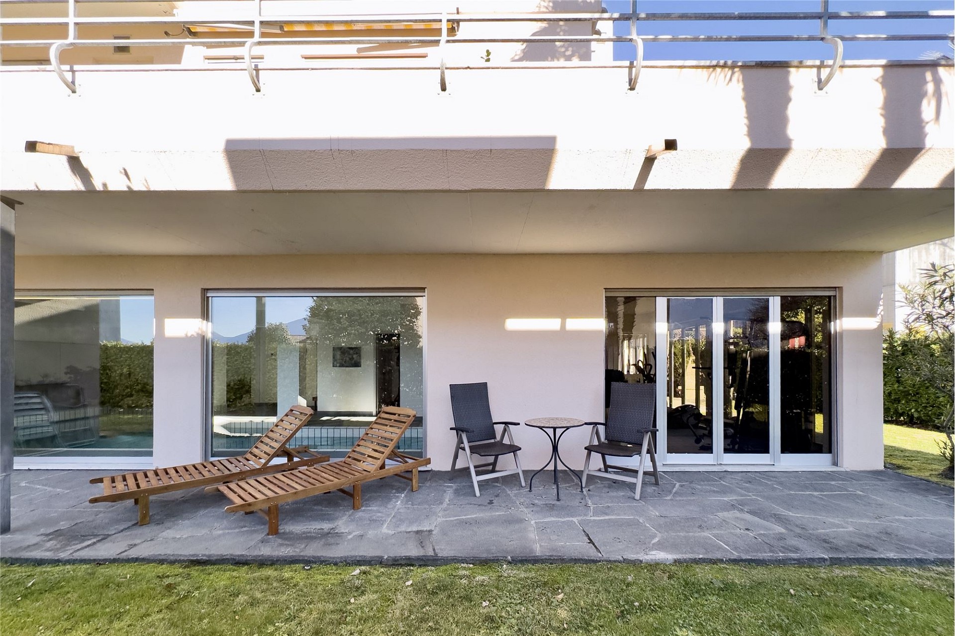 Moderne Terrassenansicht eines Hauses mit Liegestühlen