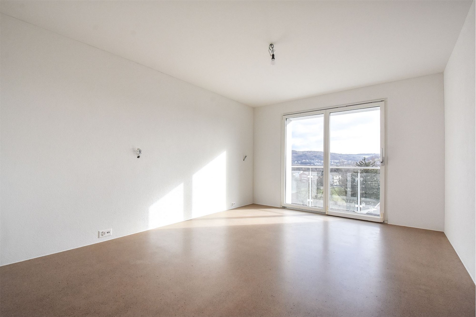 Leerer Wohnraum mit Balkonblick