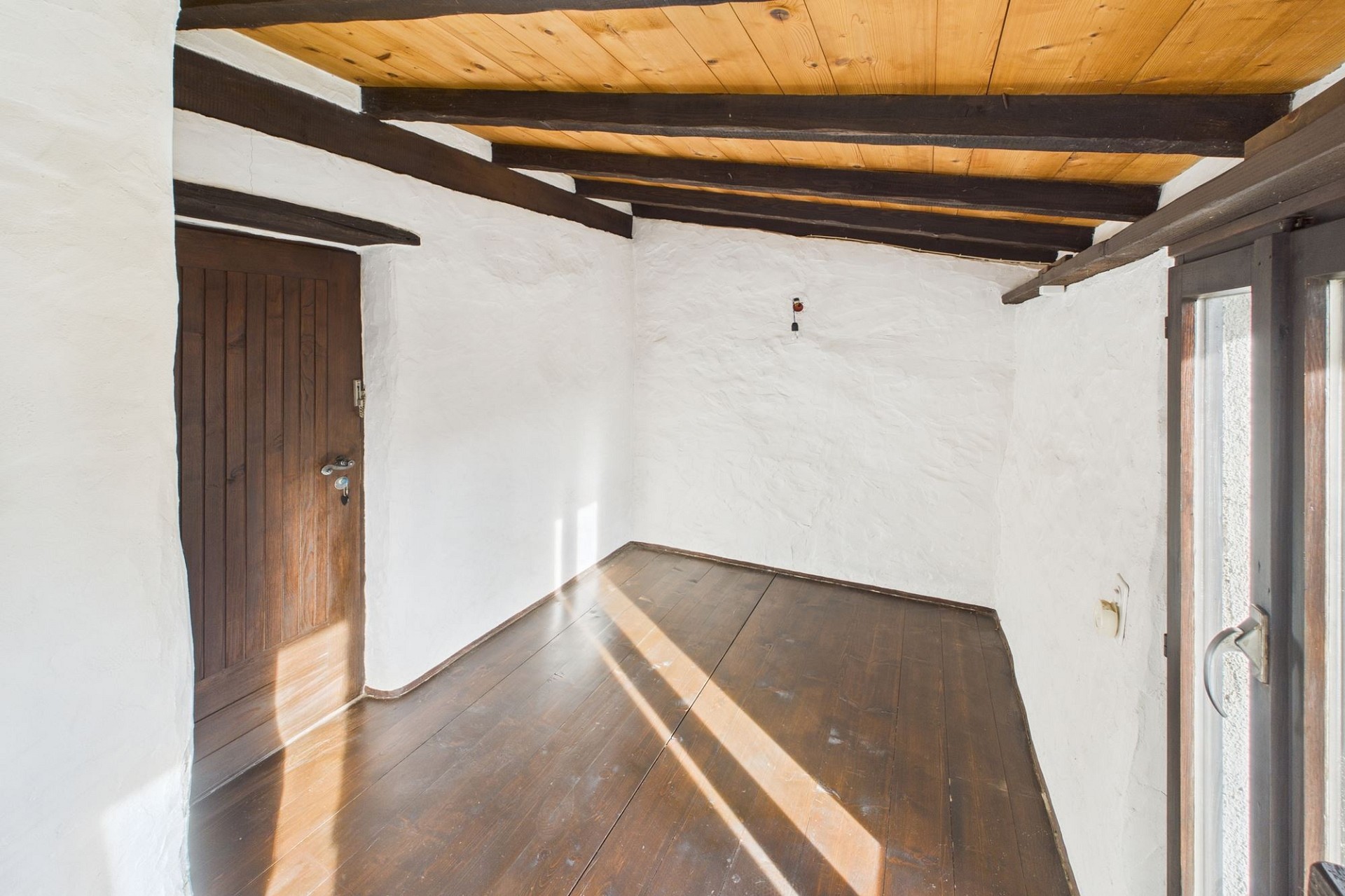Kleiner leerer Raum mit Holzbalkendecke