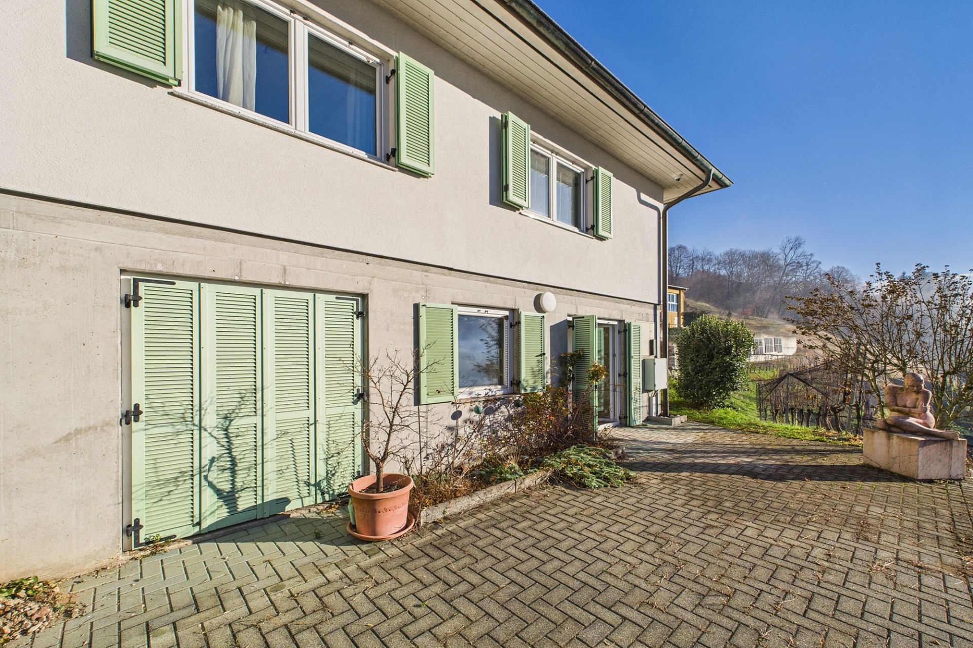 Hausansicht mit Fensterläden und Terrasse