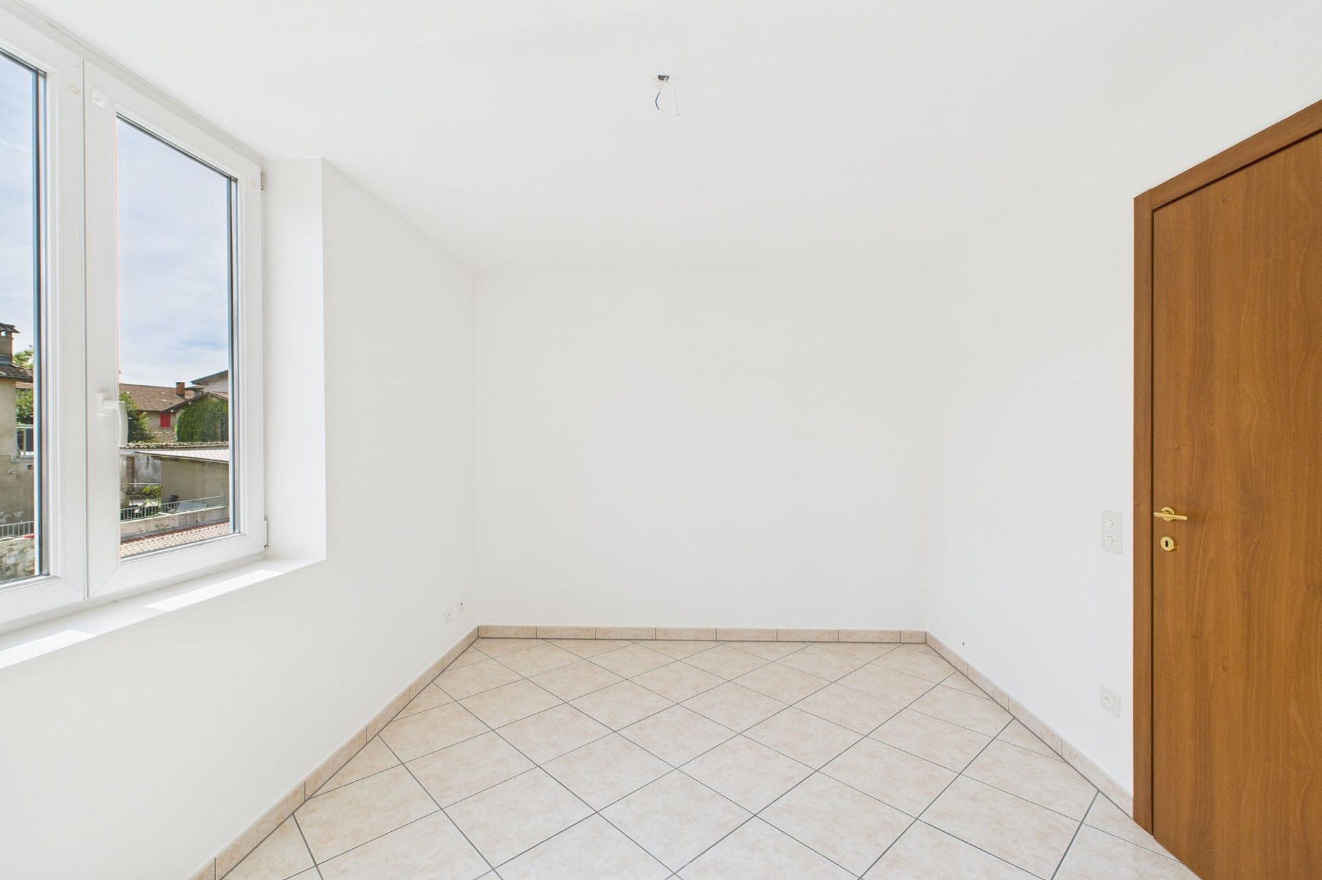 Heller leerer Raum mit Fliesenboden und Fenster