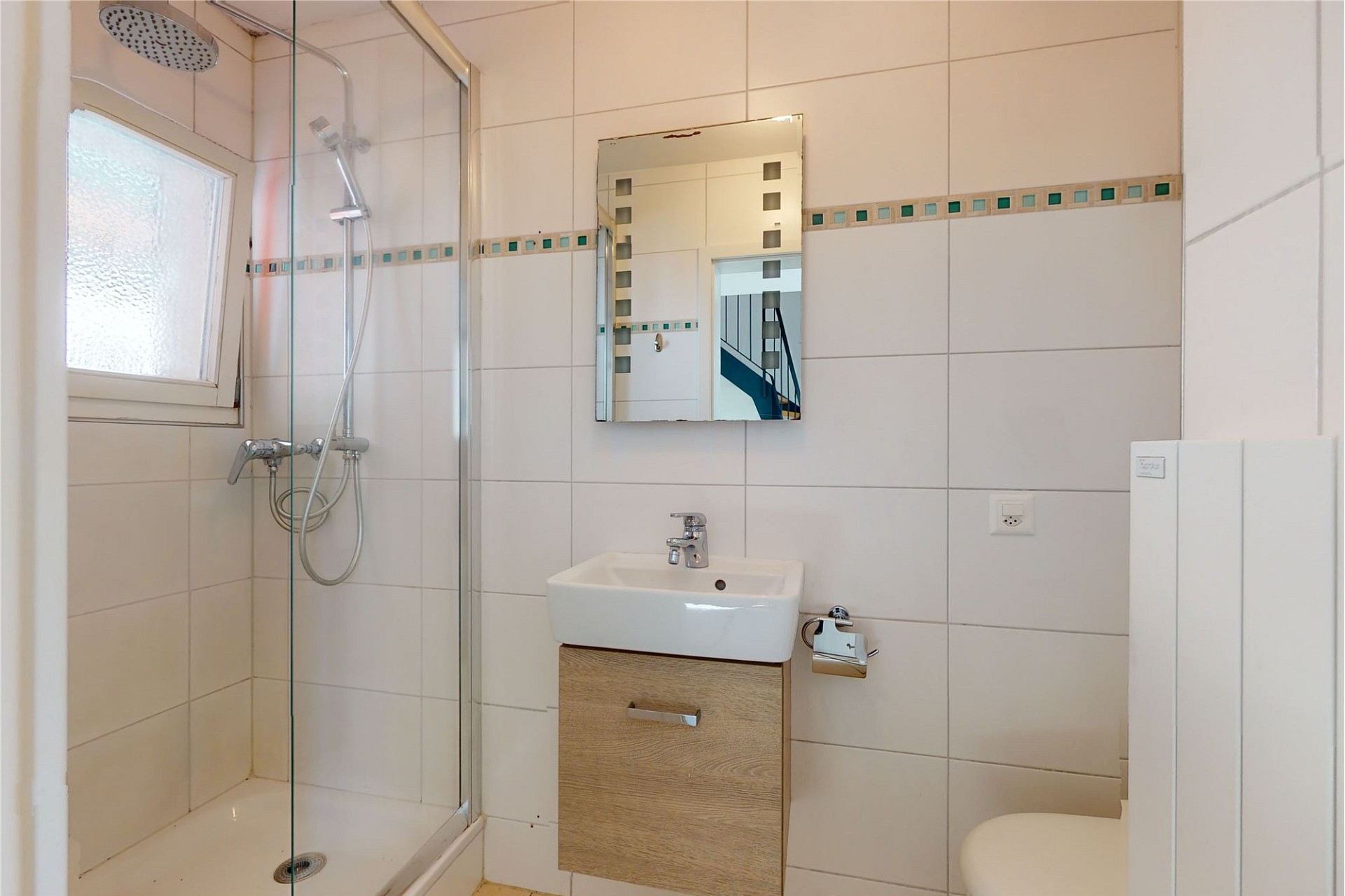 Kleines, helles Badezimmer mit Dusche und Waschtisch