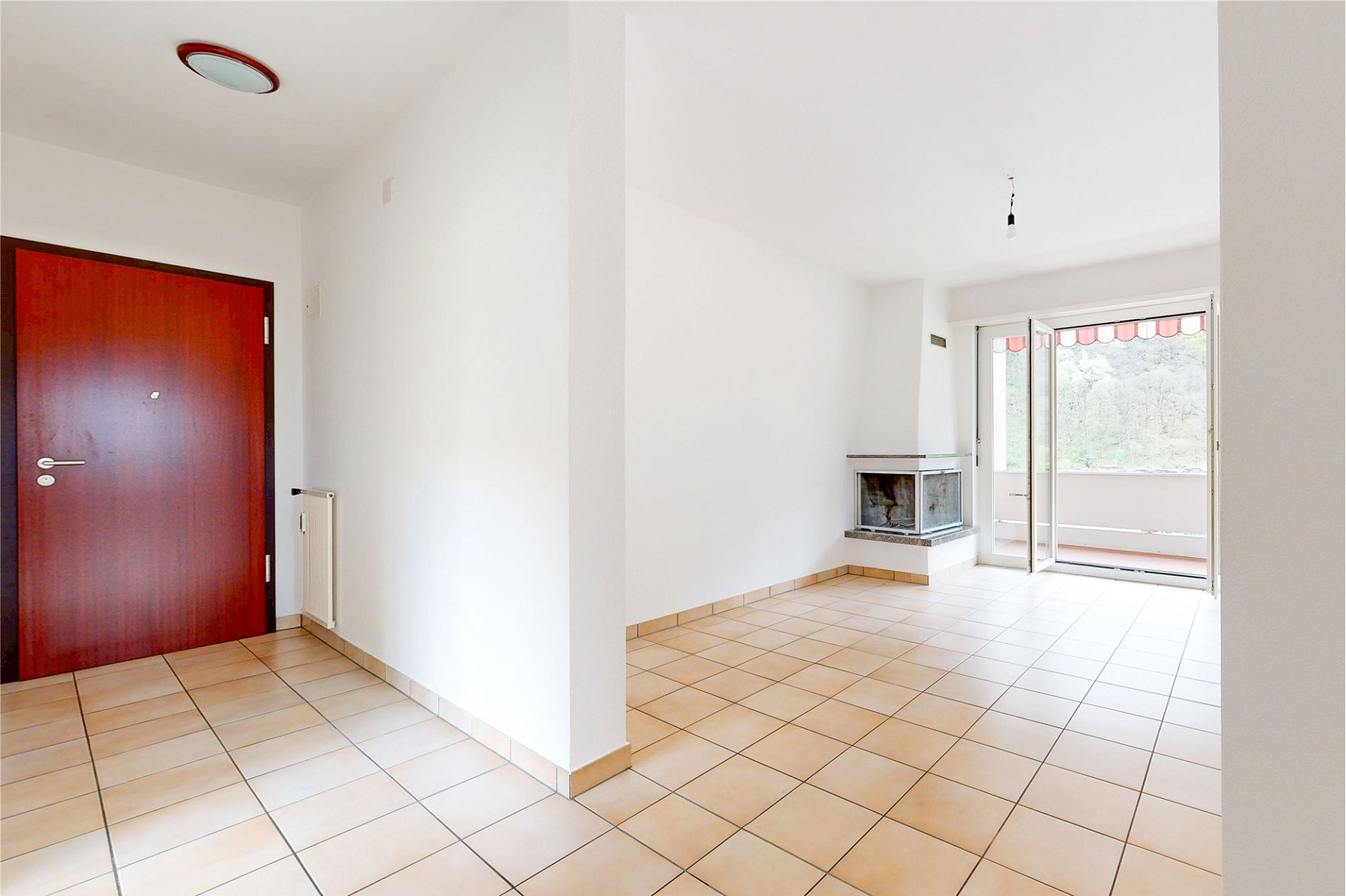 Heller Wohnraum mit Kamin und Balkonzugang