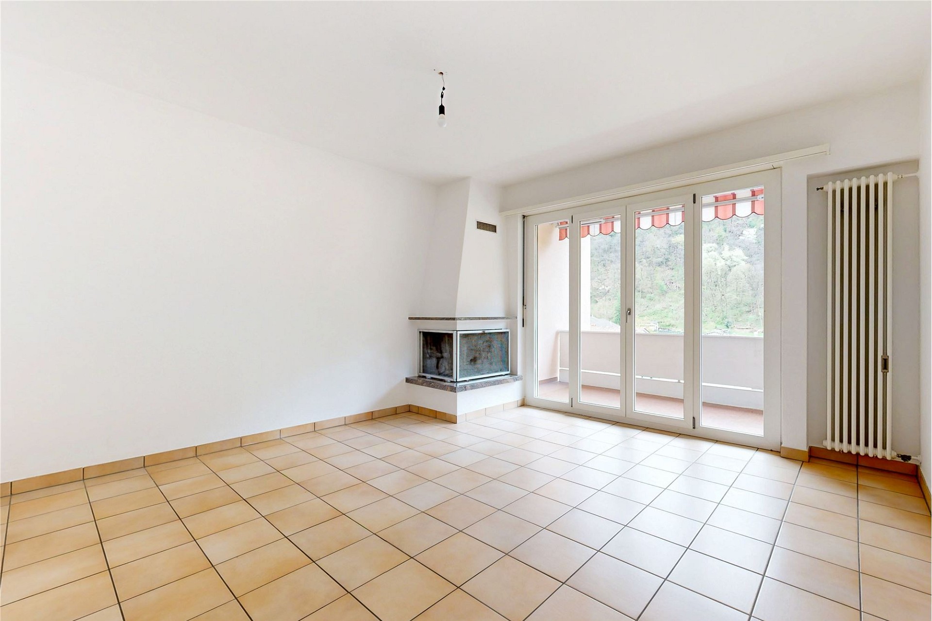 Heller Wohnraum mit Kamin und Balkonzugang