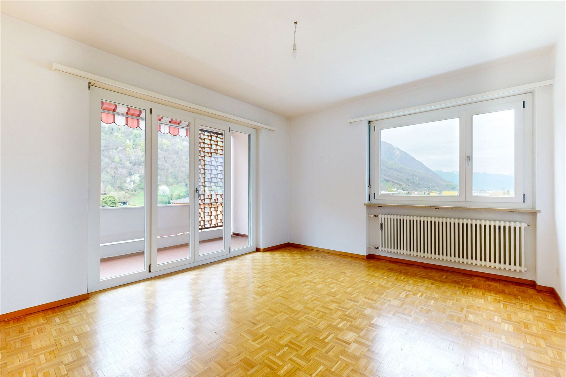 Heller leerer Raum mit Balkon und Bergblick