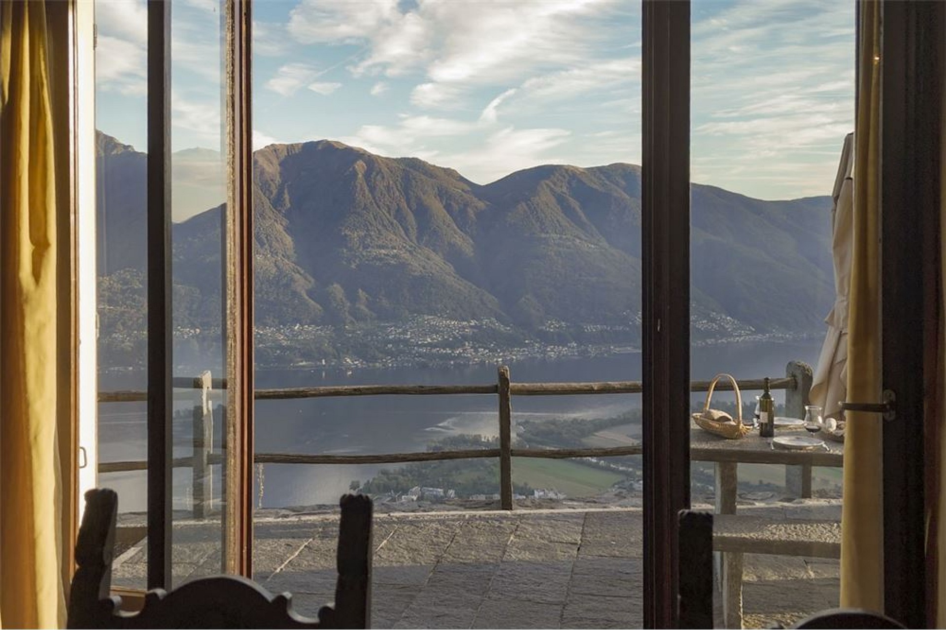 Berg- und Seeblick durch eine große Fensterfront