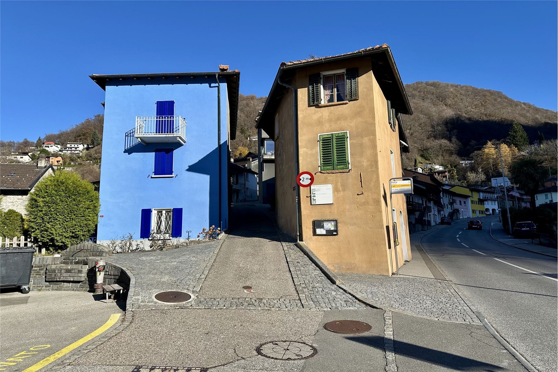 Straßenansicht mit zwei schmalen Häusern an einer Hanglage
