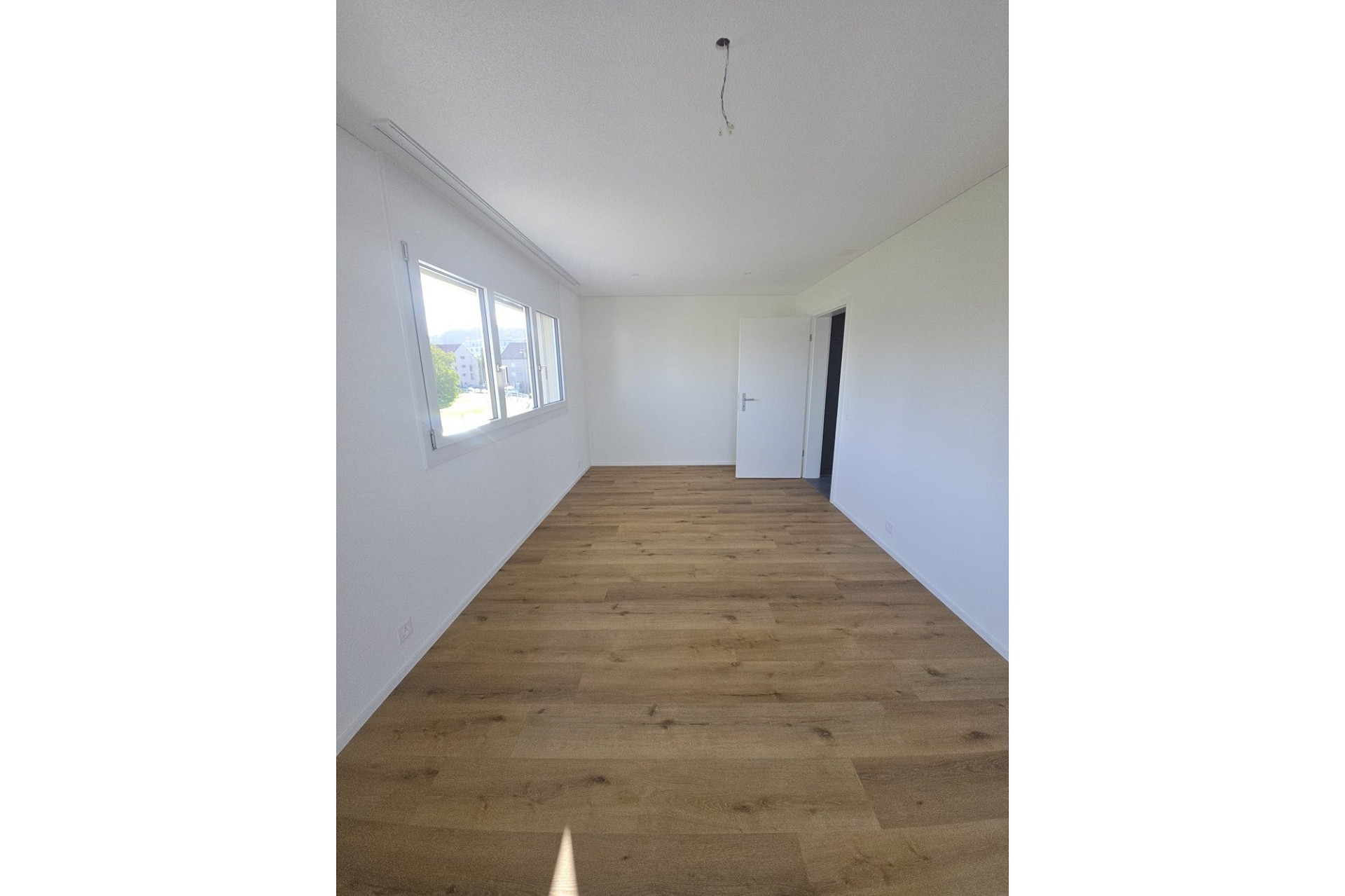 Helles, leerstehendes Schlafzimmer mit Holzboden